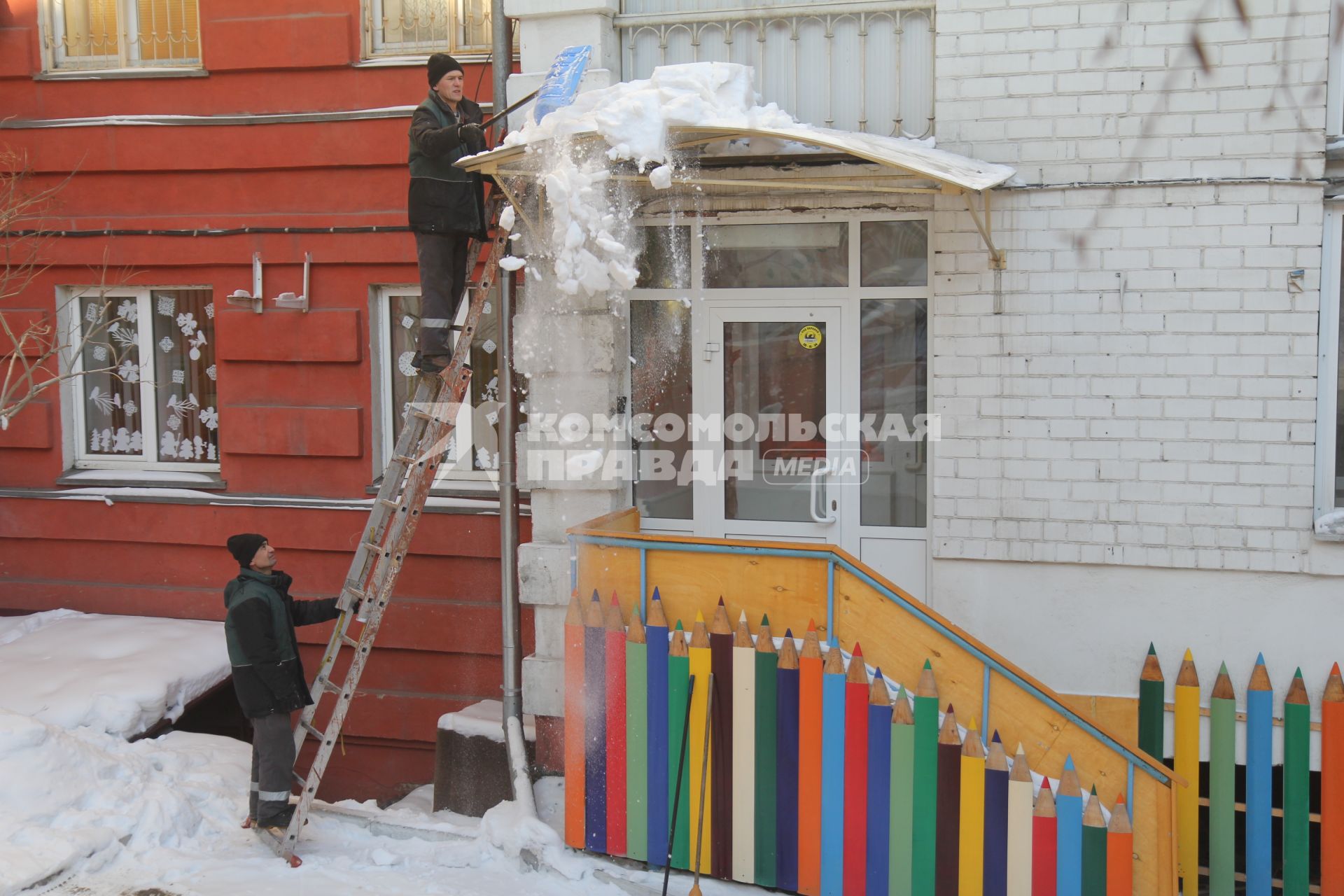 Иркутск. Мужчина сбрасывает снег с крыши.