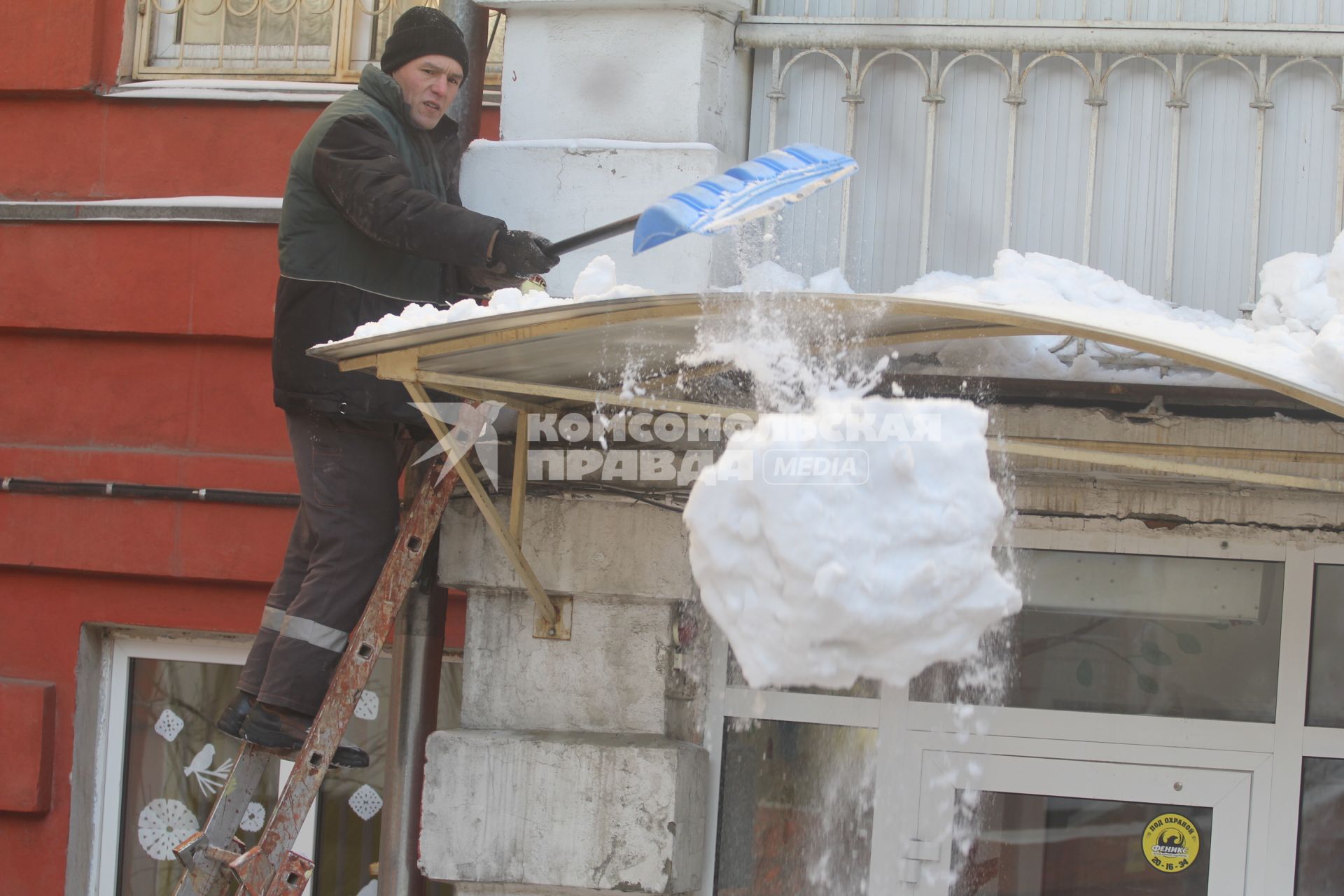 Иркутск. Мужчина сбрасывает снег с крыши.