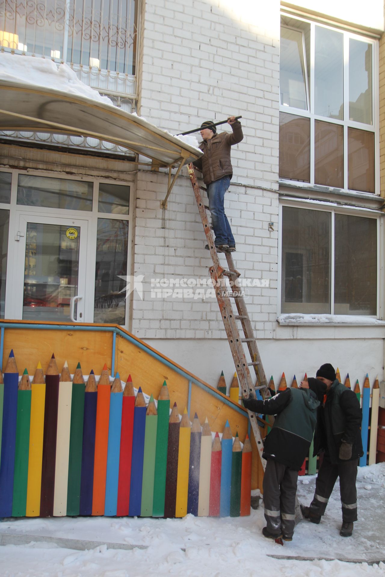 Иркутск. Мужчина сбрасывает снег с крыши.