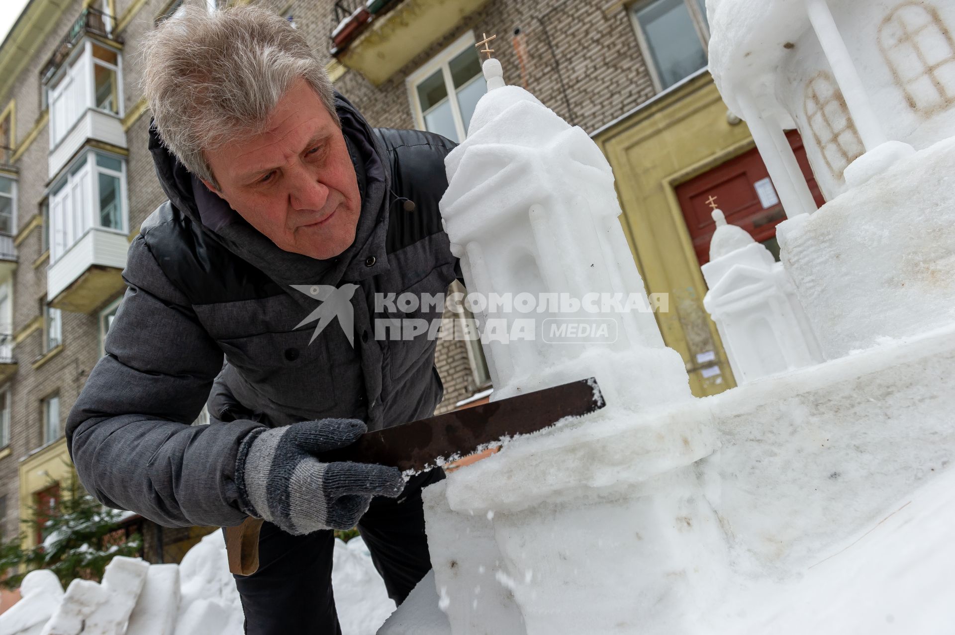 Санкт-Петербург.  Петербуржец Владимир Кузьмин во время изготовления снежной скульптуры Исаакиевского собора во вдоре своего дома.