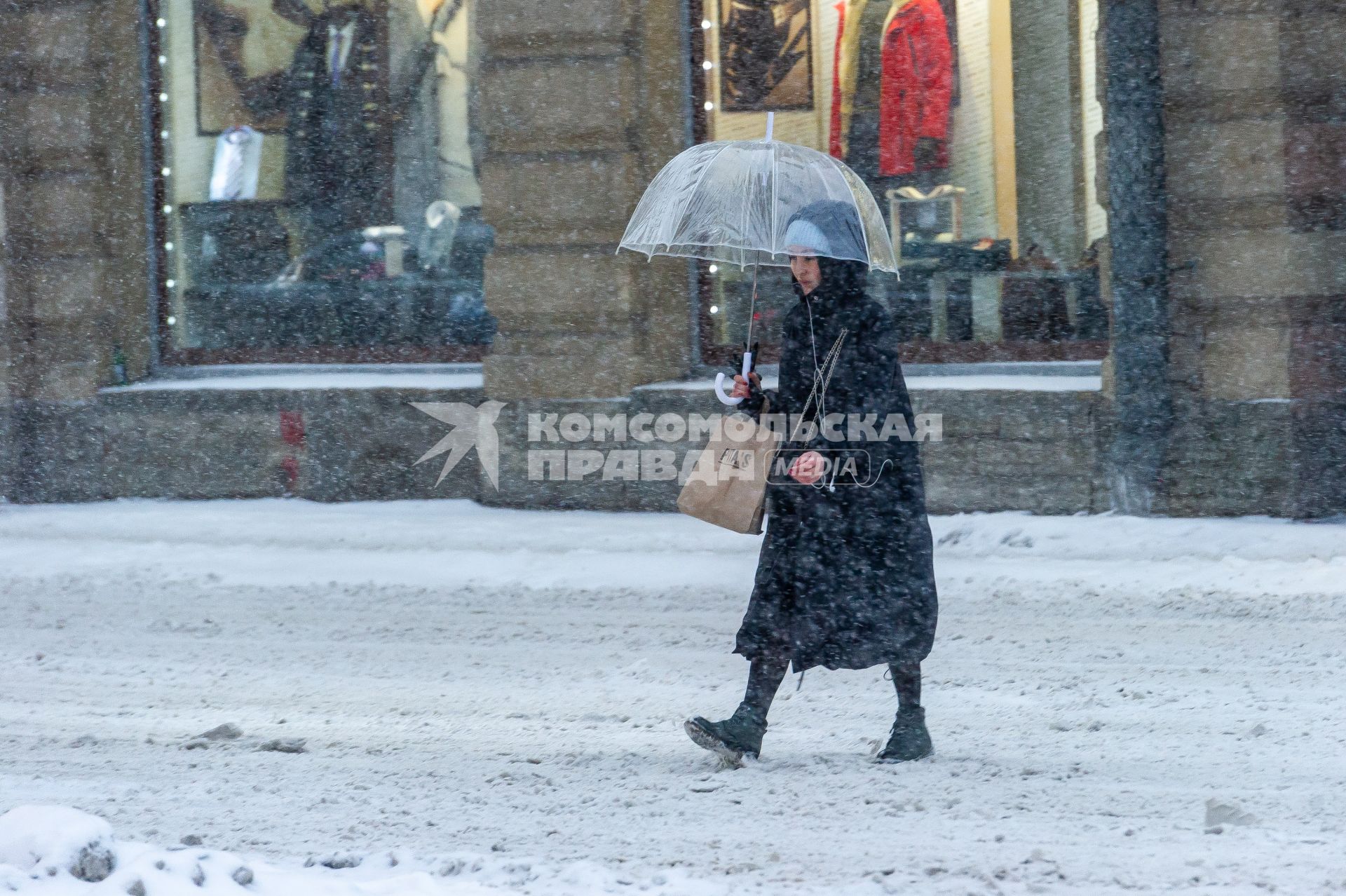 Санкт-Петербург. Женщина под зонтом на заснеженной улице.