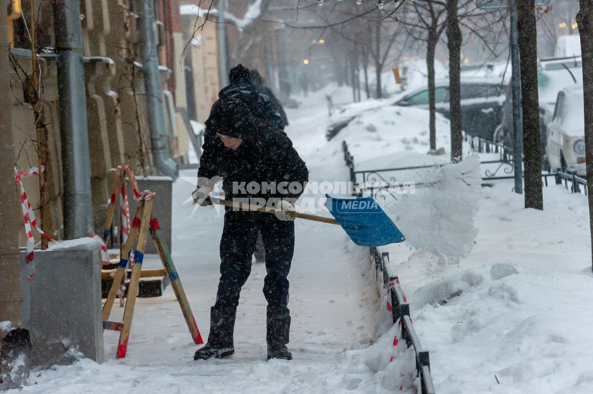 Санкт-Петербург. Мужчина чистит от снега тротуар.