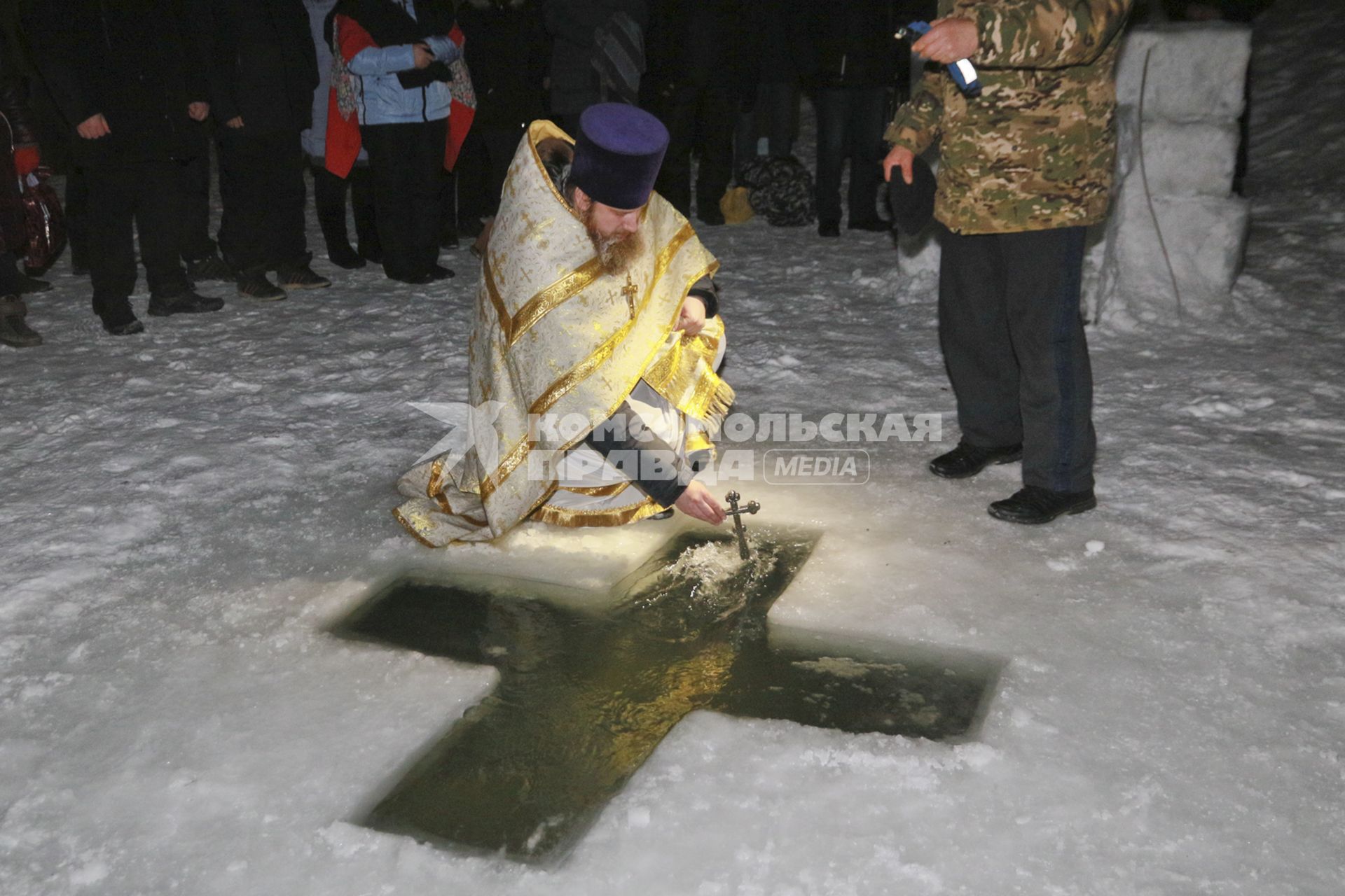 Барнаул. Священник православным крестом освящает воду перед крещенскими купаниями в праздник Крещения Господня.