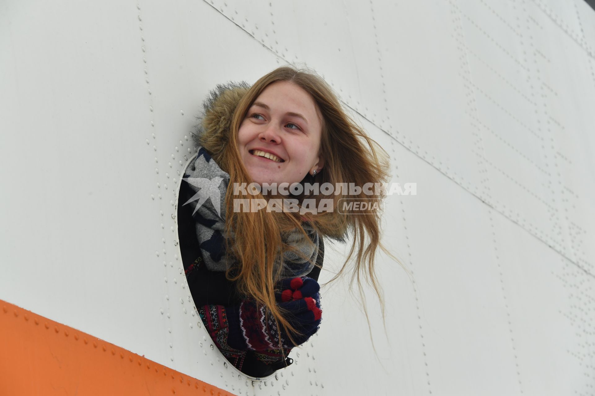 Москва. Девушка в иллюминаторе  вертолета на аэродроме `Остафьево` в московском авиационном  центре.