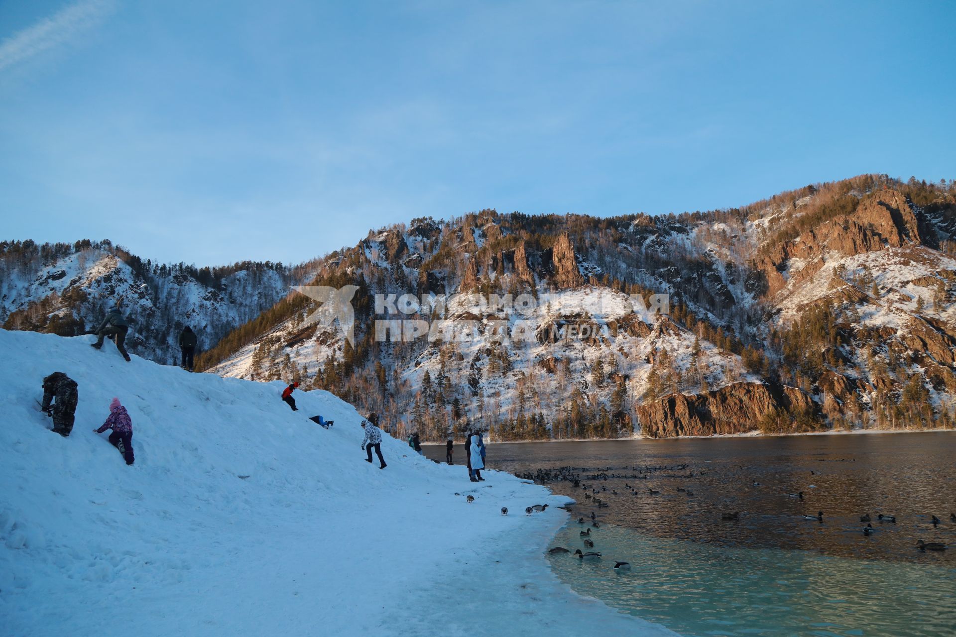 Красноярский край,  Дивногорск. Люди  наблюдают за утками у реки Енисей.