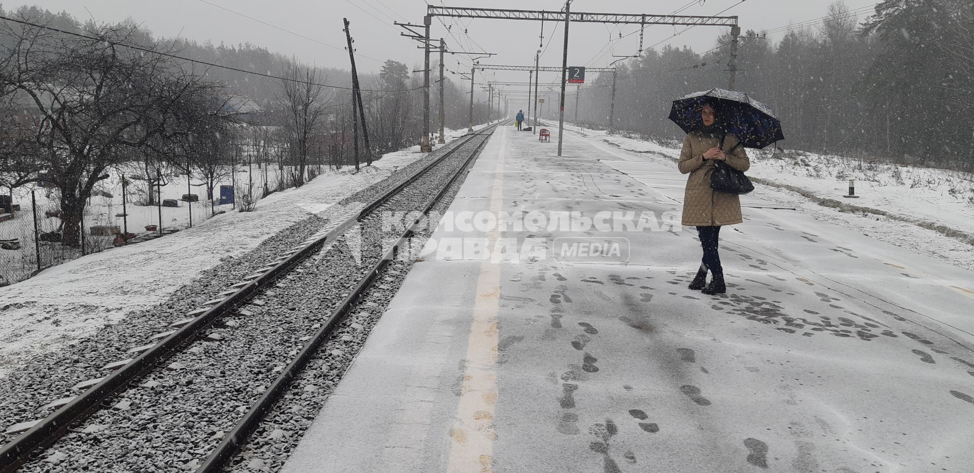 Московская область. Девушка ждет электричку на перроне во время снегопада.