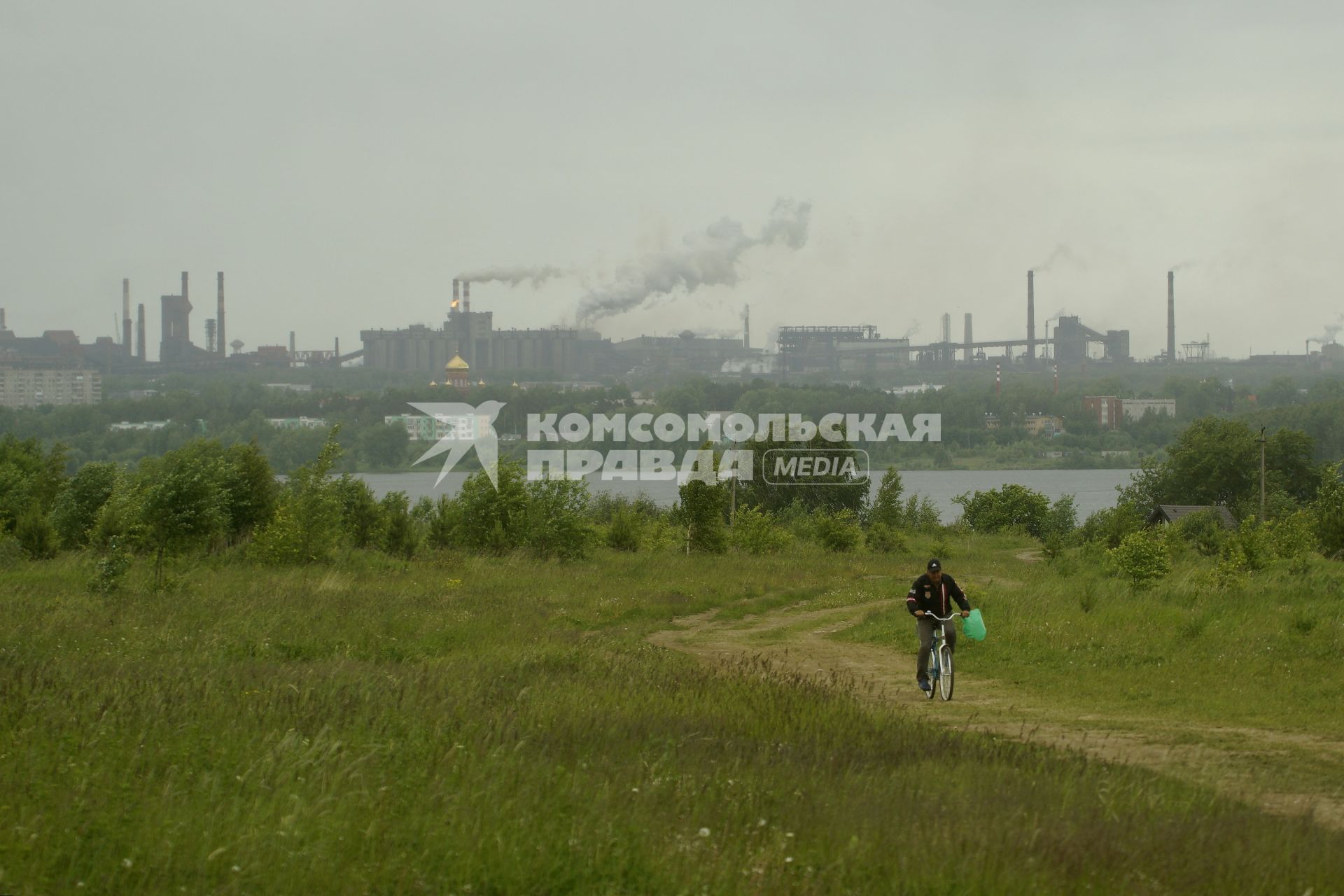 Свердловская область. Нижний Тагил. Мужчина на велосипеде едет по пустырю, где планируется строительство моста