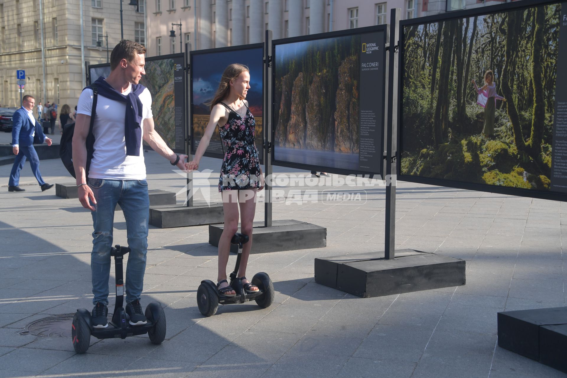 Москва.  Молодые люди на сегвеях осматривают уличную фотовыставку на Кузнецком мосту.