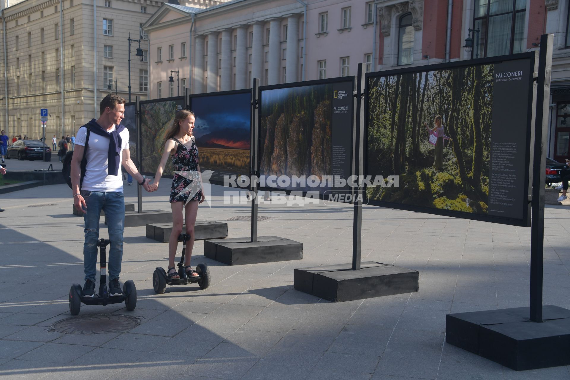 Москва.  Молодые люди на сегвеях осматривают уличную фотовыставку на Кузнецком мосту.