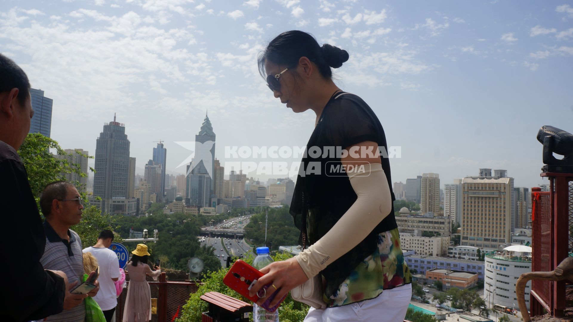 Китай, Урумчи.   Женщина на вершине Красного Холма в центре города. A woman on the top of the Red Hill Park in ??r??mqi, the capital of the Xinjiang Uygur Autonomous Region of China.