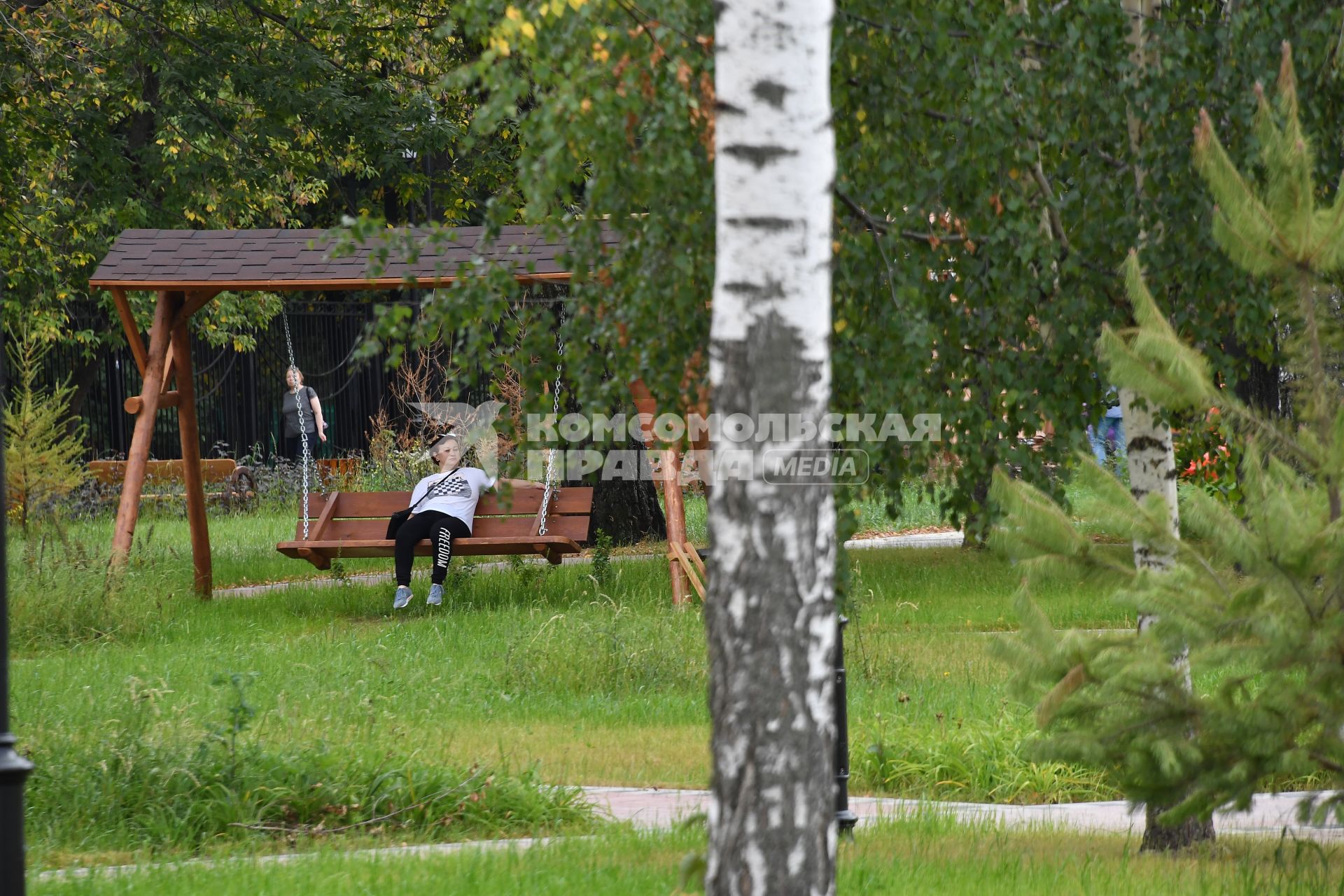 Москва. Женщина на качелях в Детском Черкизовском парке.