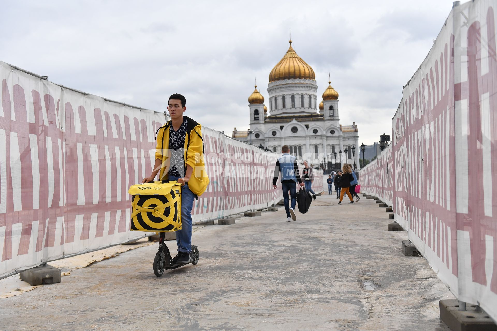 Москва. Сотрудник сервиса по доставке еды `Яндекс Еда` на Патриаршем мосту.