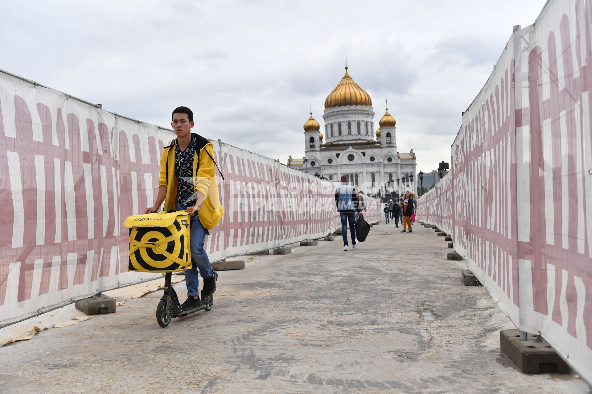 Москва. Сотрудник сервиса по доставке еды `Яндекс Еда` на Патриаршем мосту.