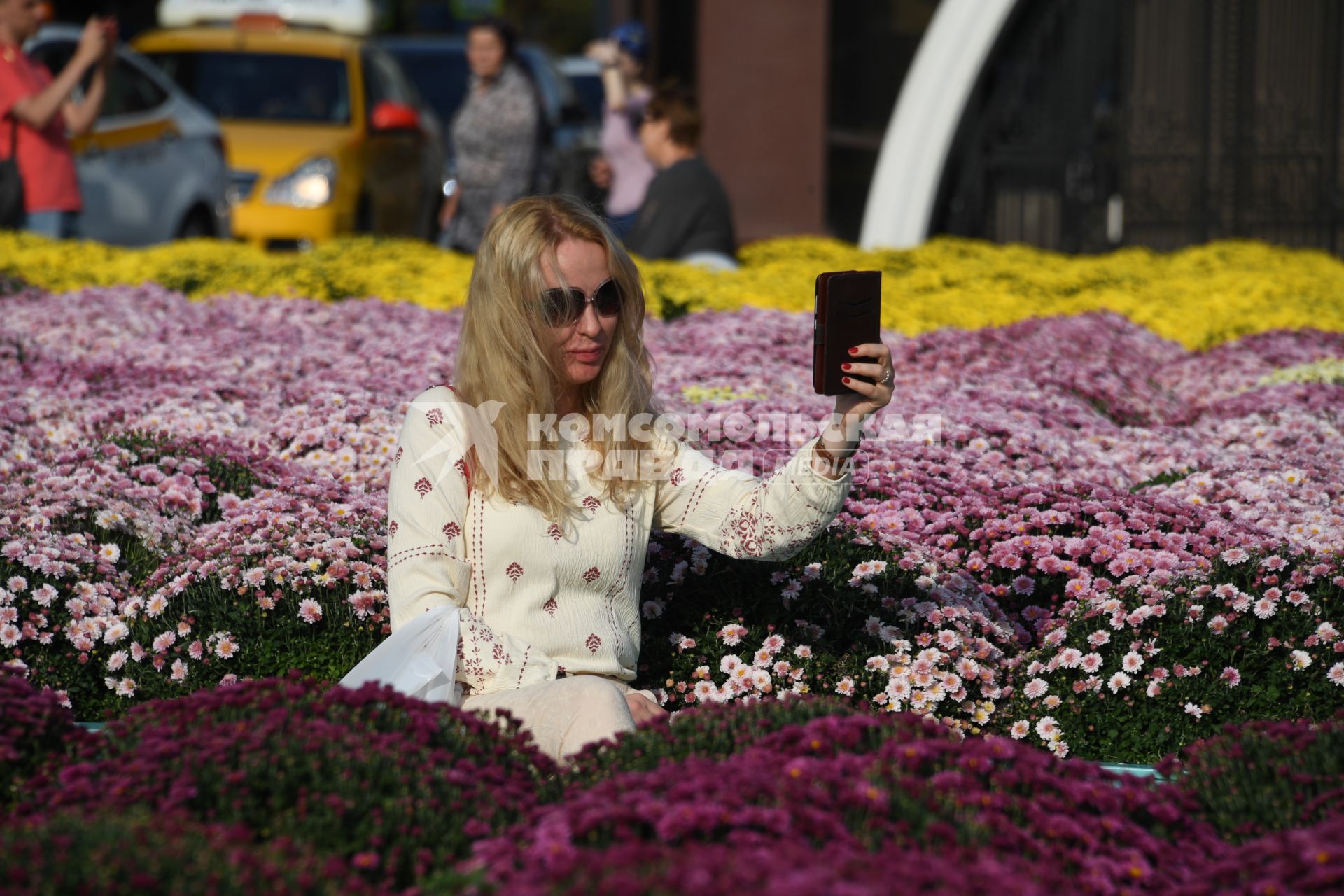 Москва.  Туристы фотографируют цветочные композиции, созданные   в рамках фестиваля `Цветочный джем` на Манежной площади.