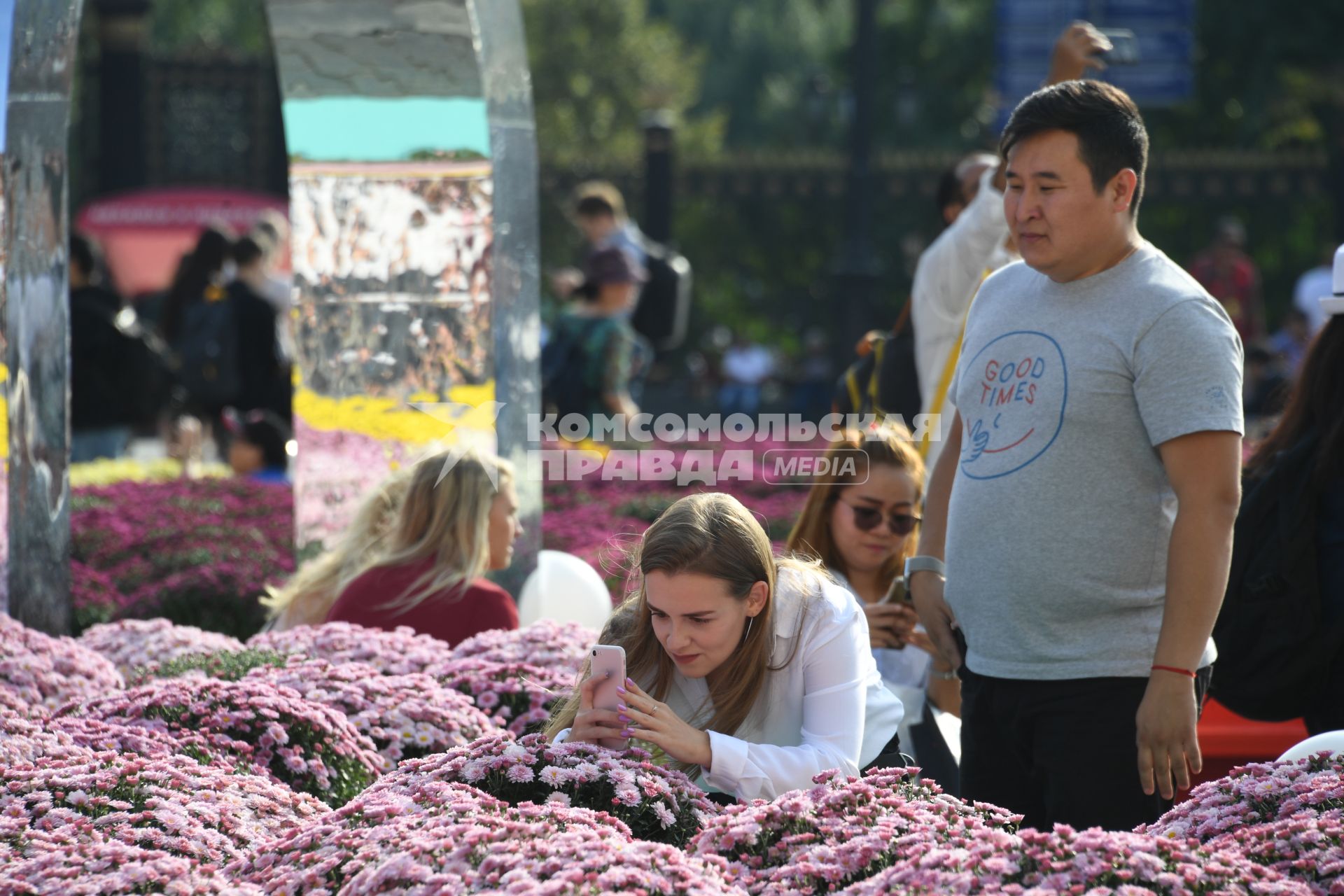 Москва.  Туристы фотографируют цветочные композиции, созданные   в рамках фестиваля `Цветочный джем` на Манежной площади.