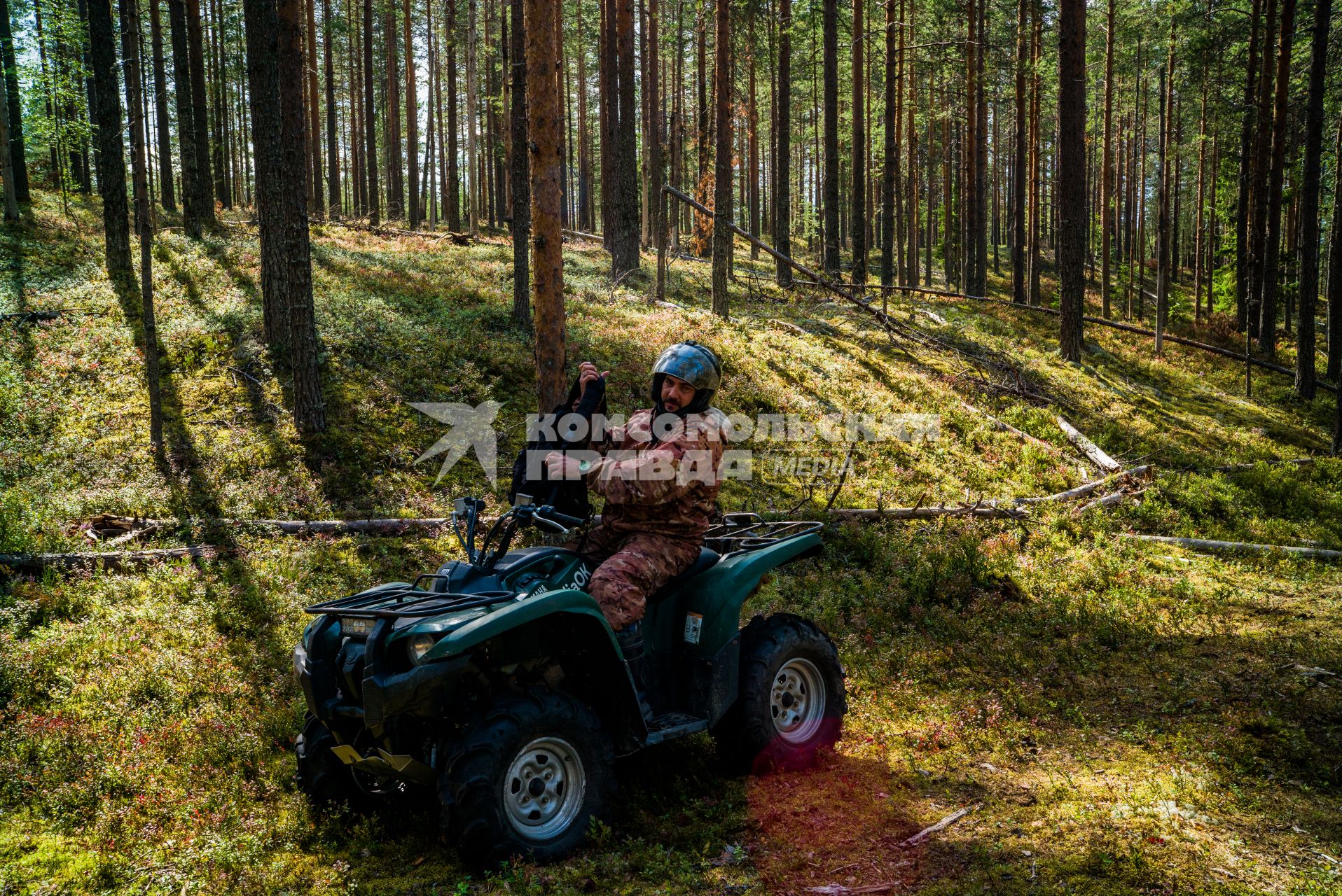 Республика Карелия,  Медвежьегорский район. Корреспондент `Комсомольской правды` Дмитрий Стешин на квадроцикле в лесу.