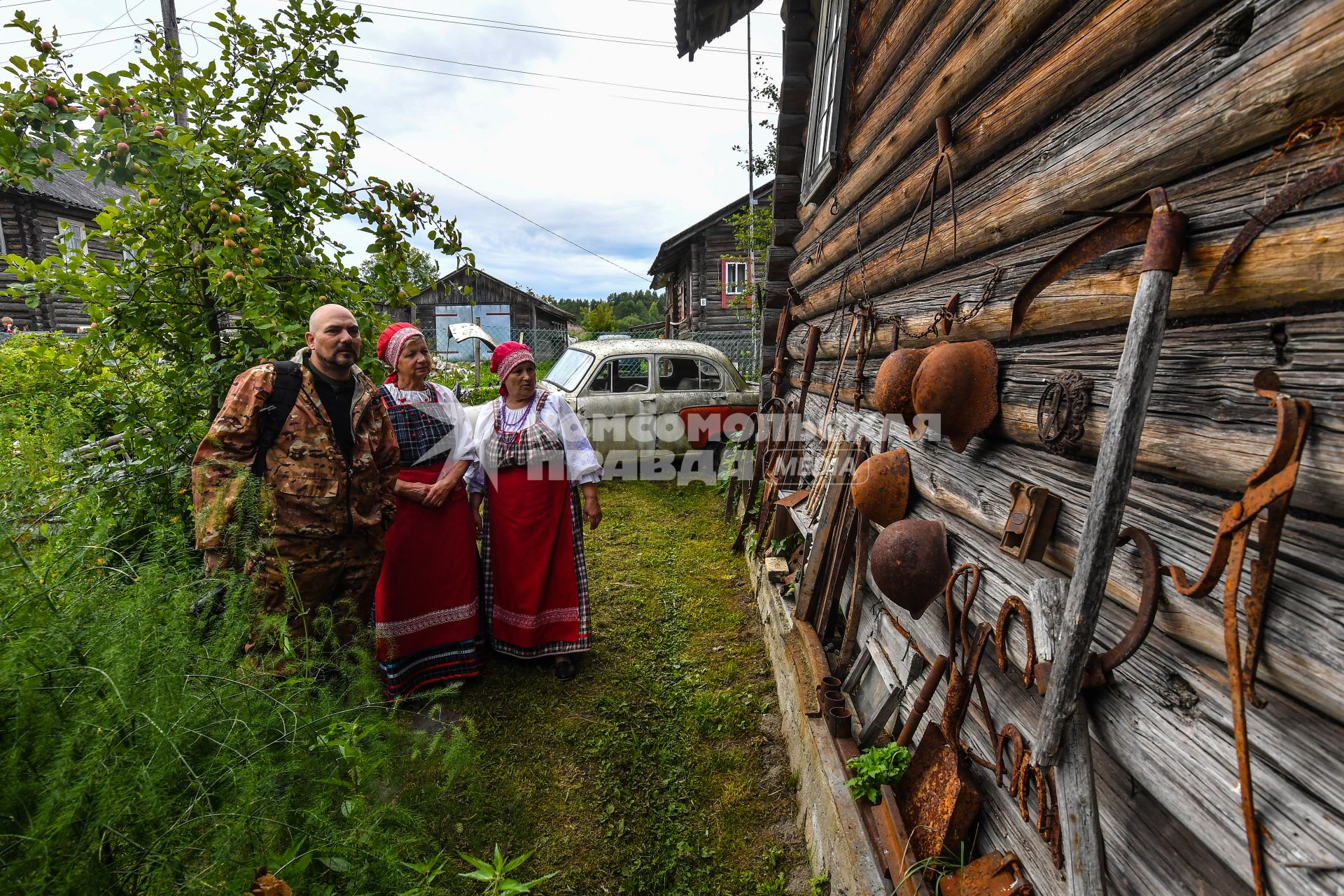 Республика Карелия, деревня Корза.  Корреспондент `Комсомольской правды` Дмитрий Стешин среди местных жительниц в национальных карельских костюмах.