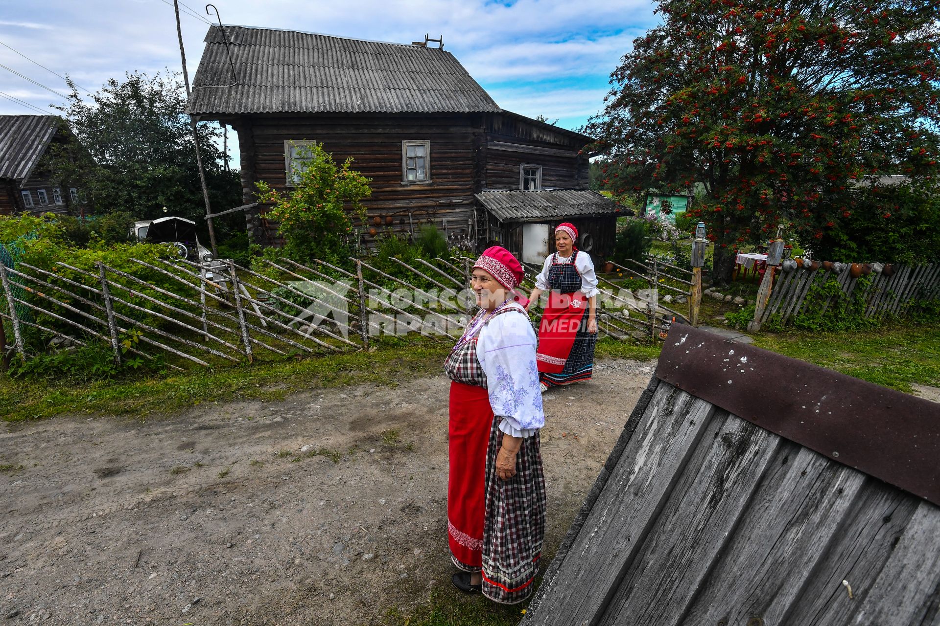 Республика Карелия, деревня Корза. Местные жительницы в национальных карельских костюмахь  на деревенской  улице.