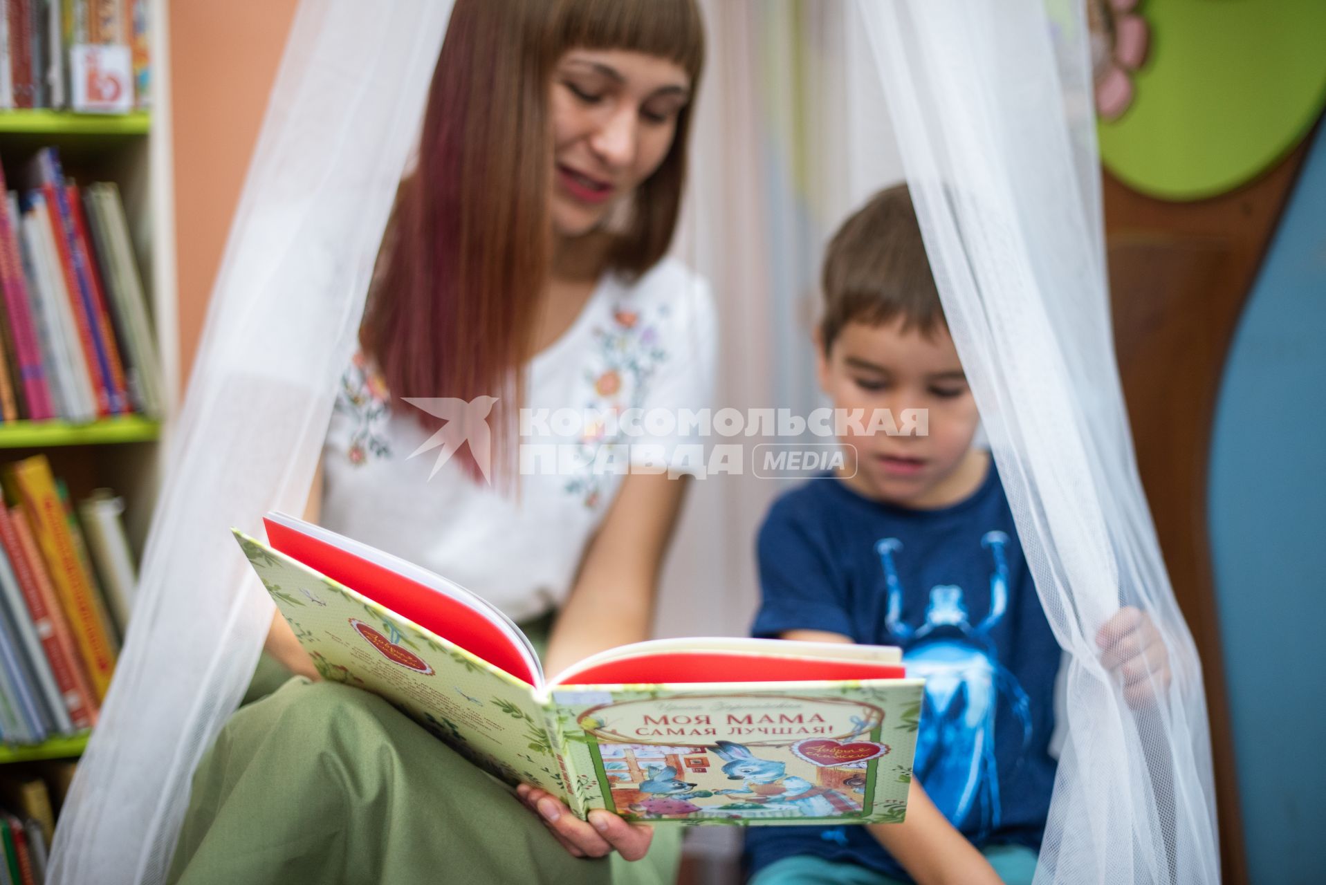 Самара. Женщина с ребенком в детской библиотеке.