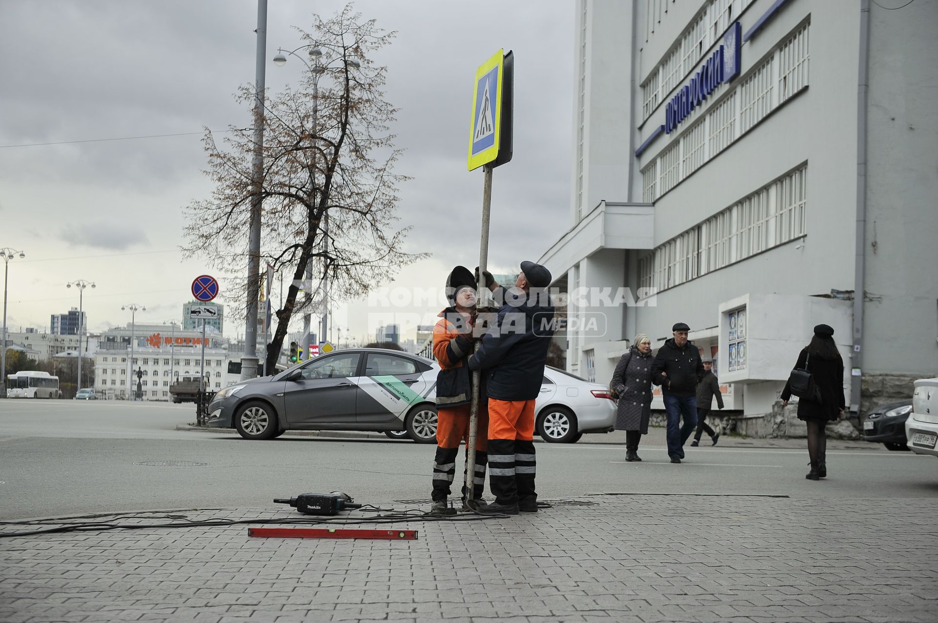 Екатеринбург. Рабочий устанавливает дорожный знак у пешеходного перехода