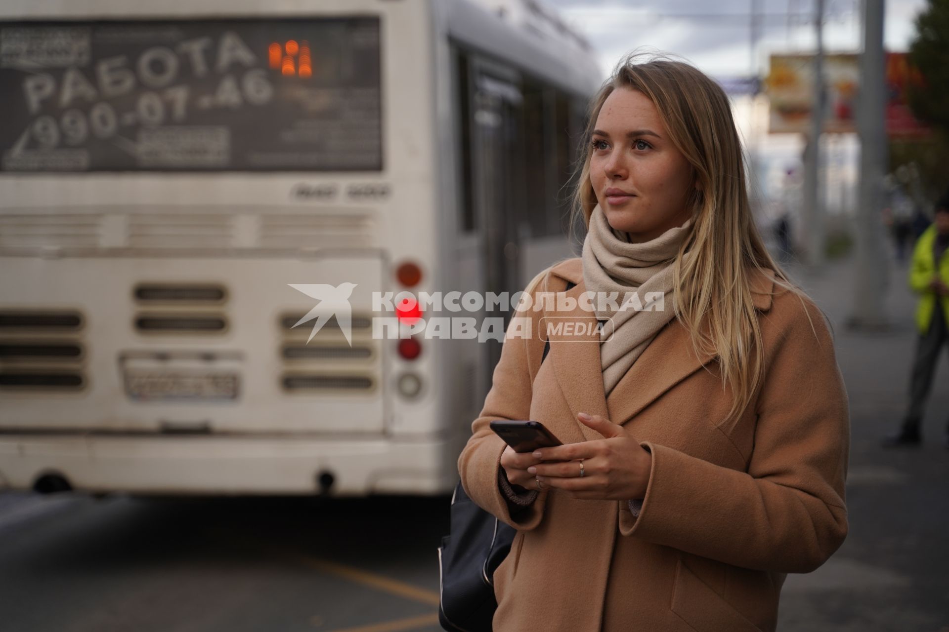 Самара. Девушка с мобильным телефоном на автобусной остановке.