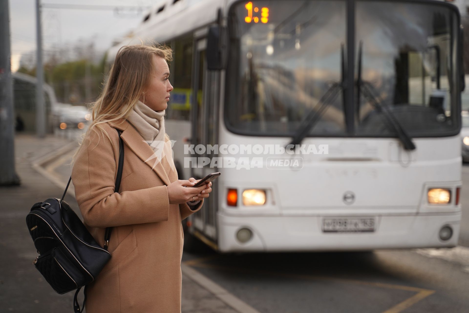 Самара. Девушка с мобильным телефоном на автобусной остановке.