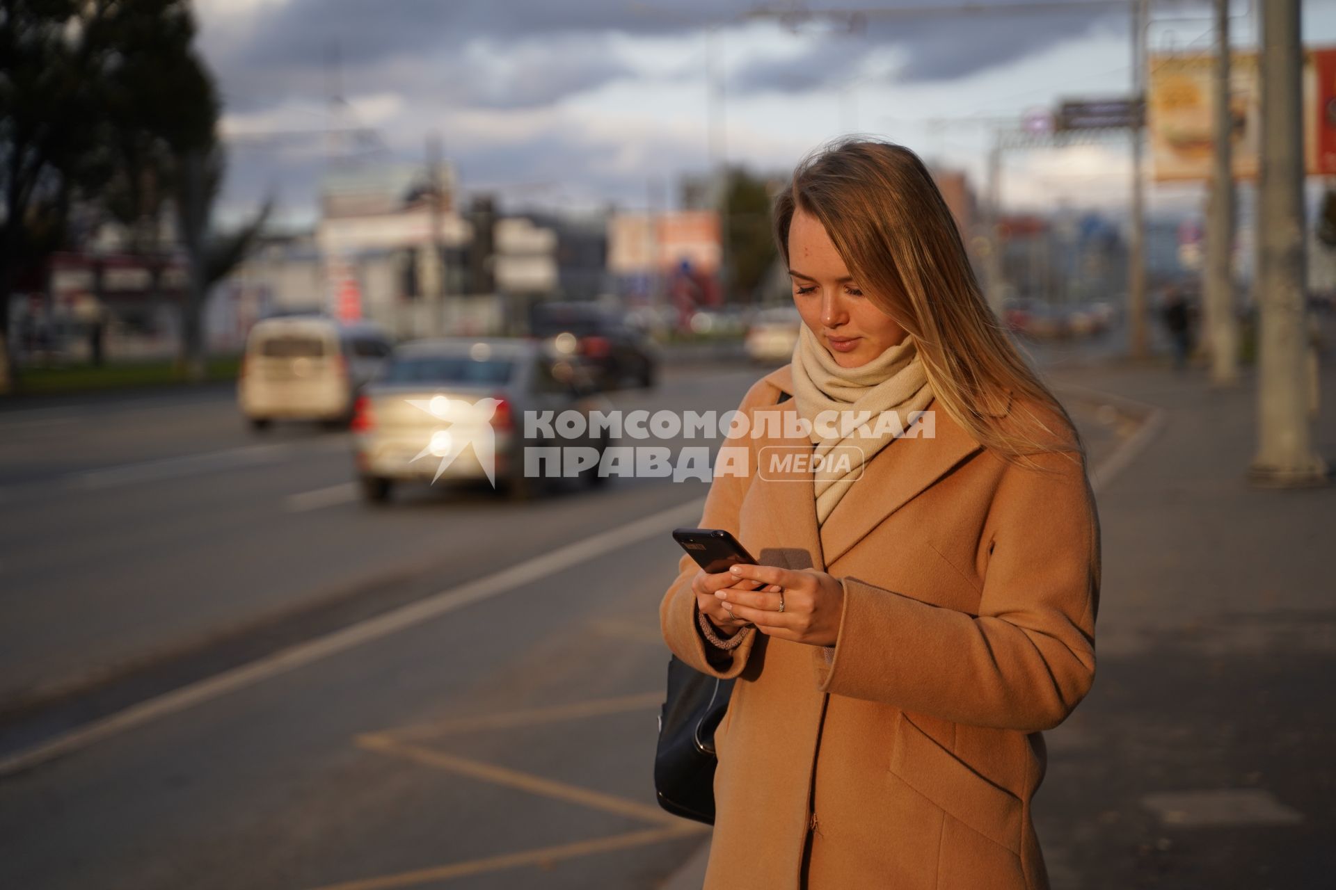 Самара. Девушка с мобильным телефоном на автобусной остановке.