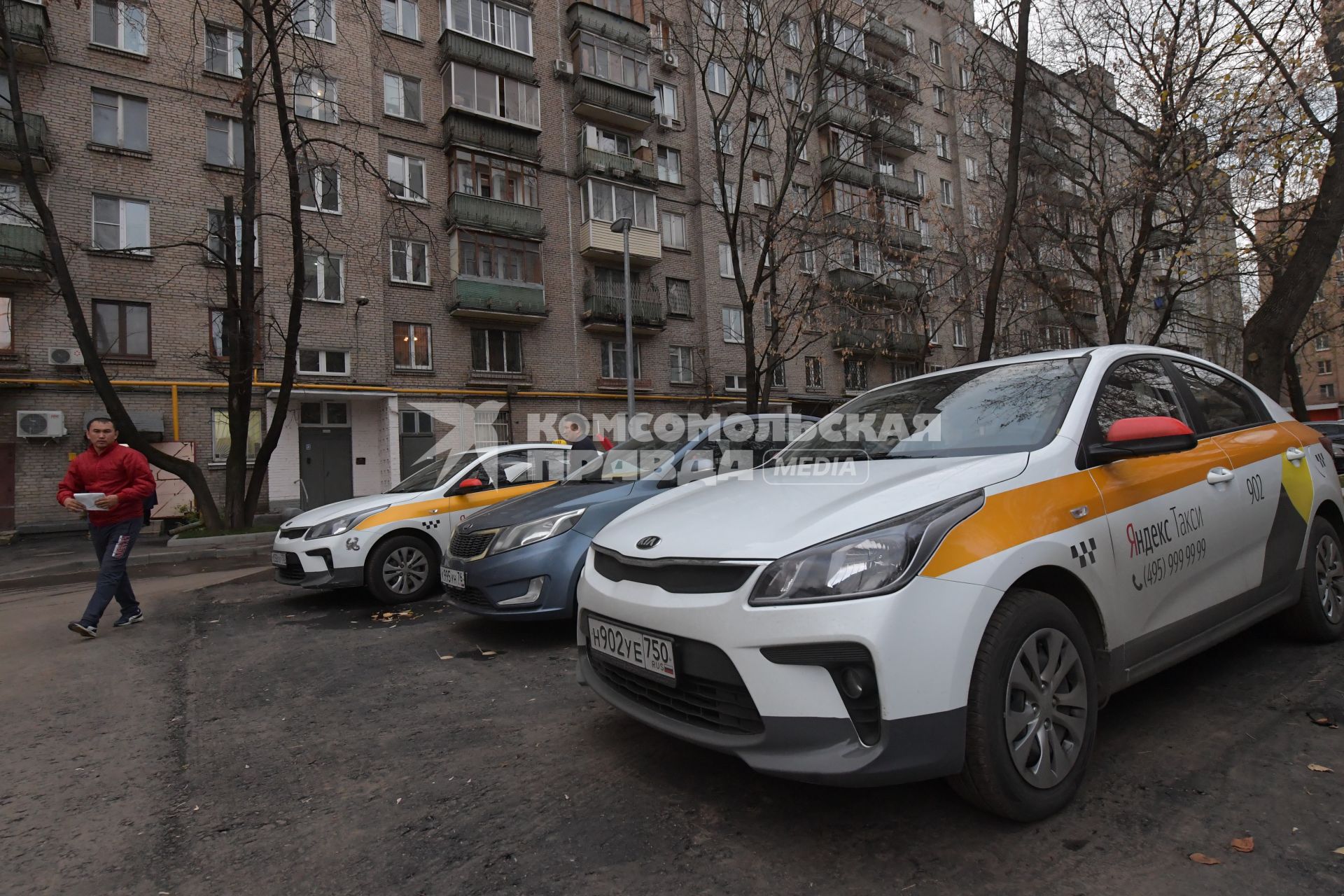 Москва.  Автомобили сервиса `Яндекс.Такси` во дворе жилого дома.