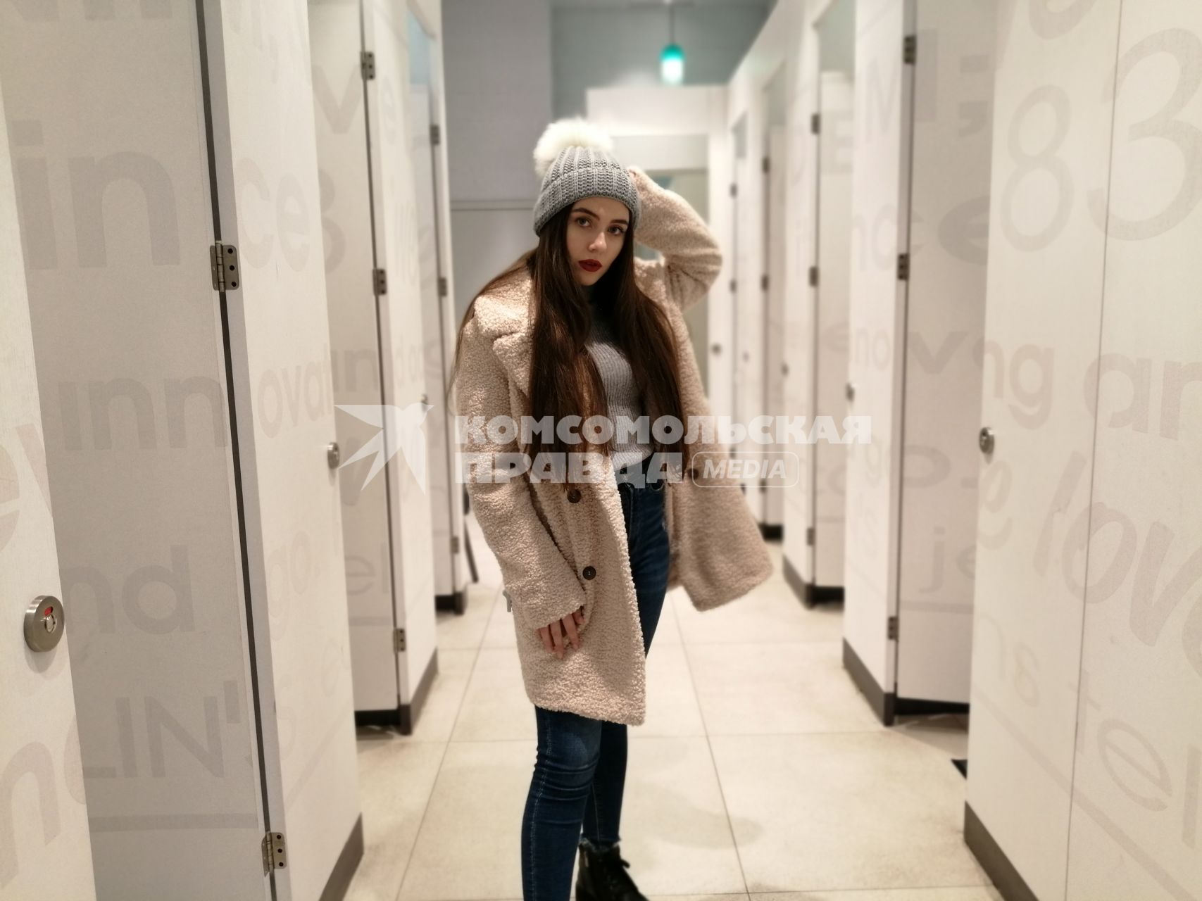 Красноярск.  Девушка в шапке и пальто в примерочной магазина.