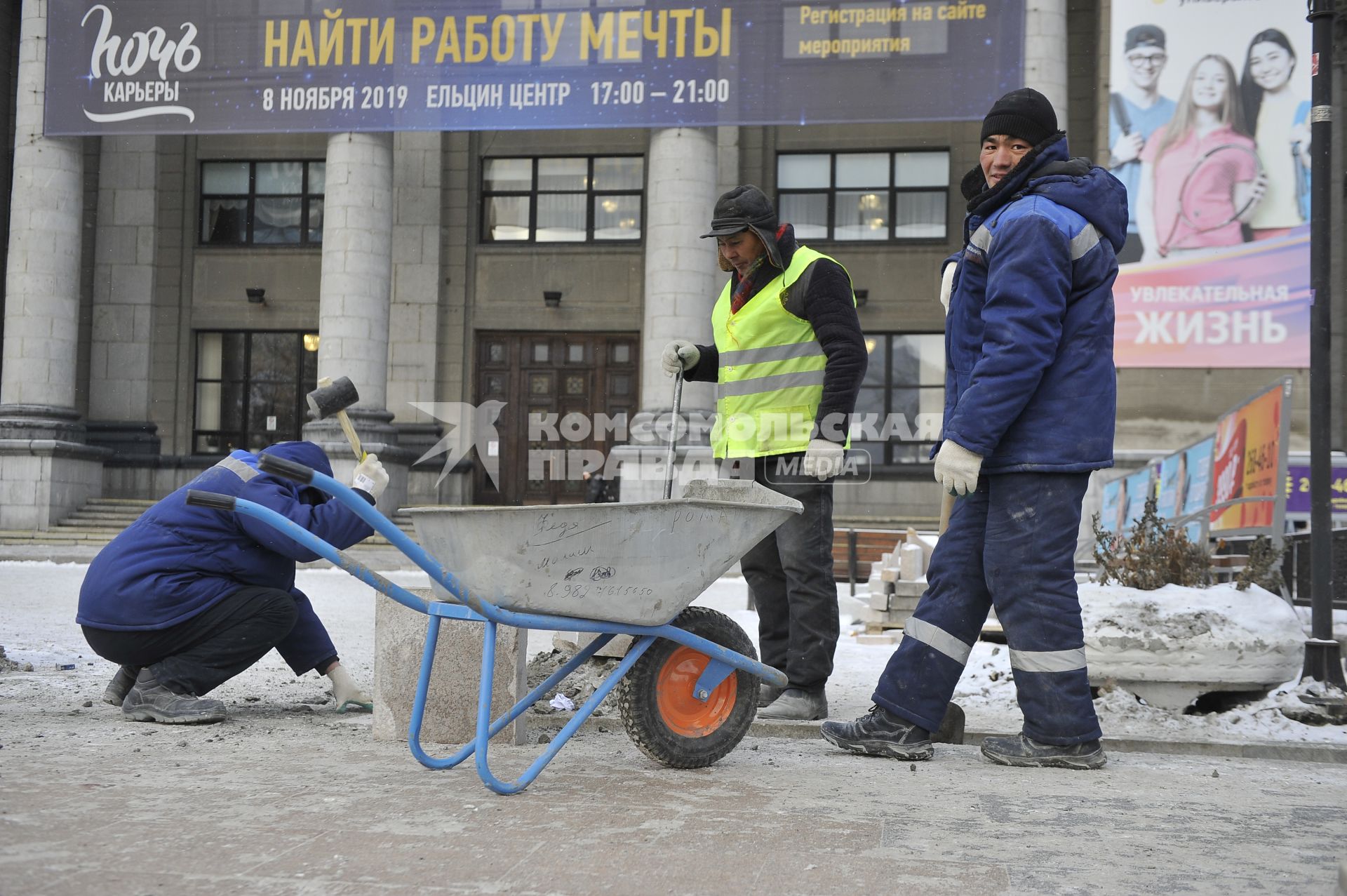 Екатеринбург. Рабочие в снег укладывают тротуарную гранитную плитку