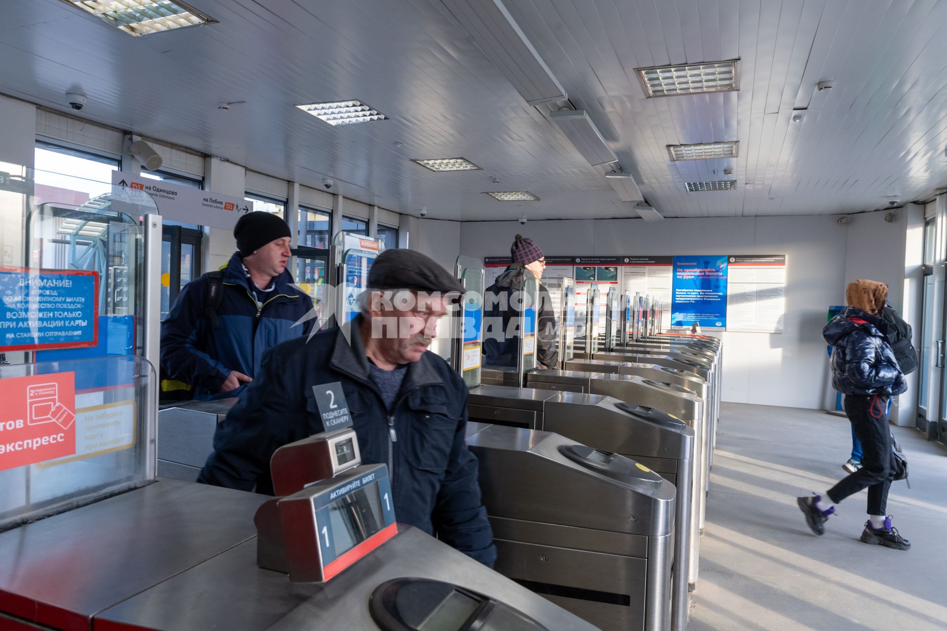 Москва. Пассажиры проходят через турникеты к поездам Московского центрального диаметра.