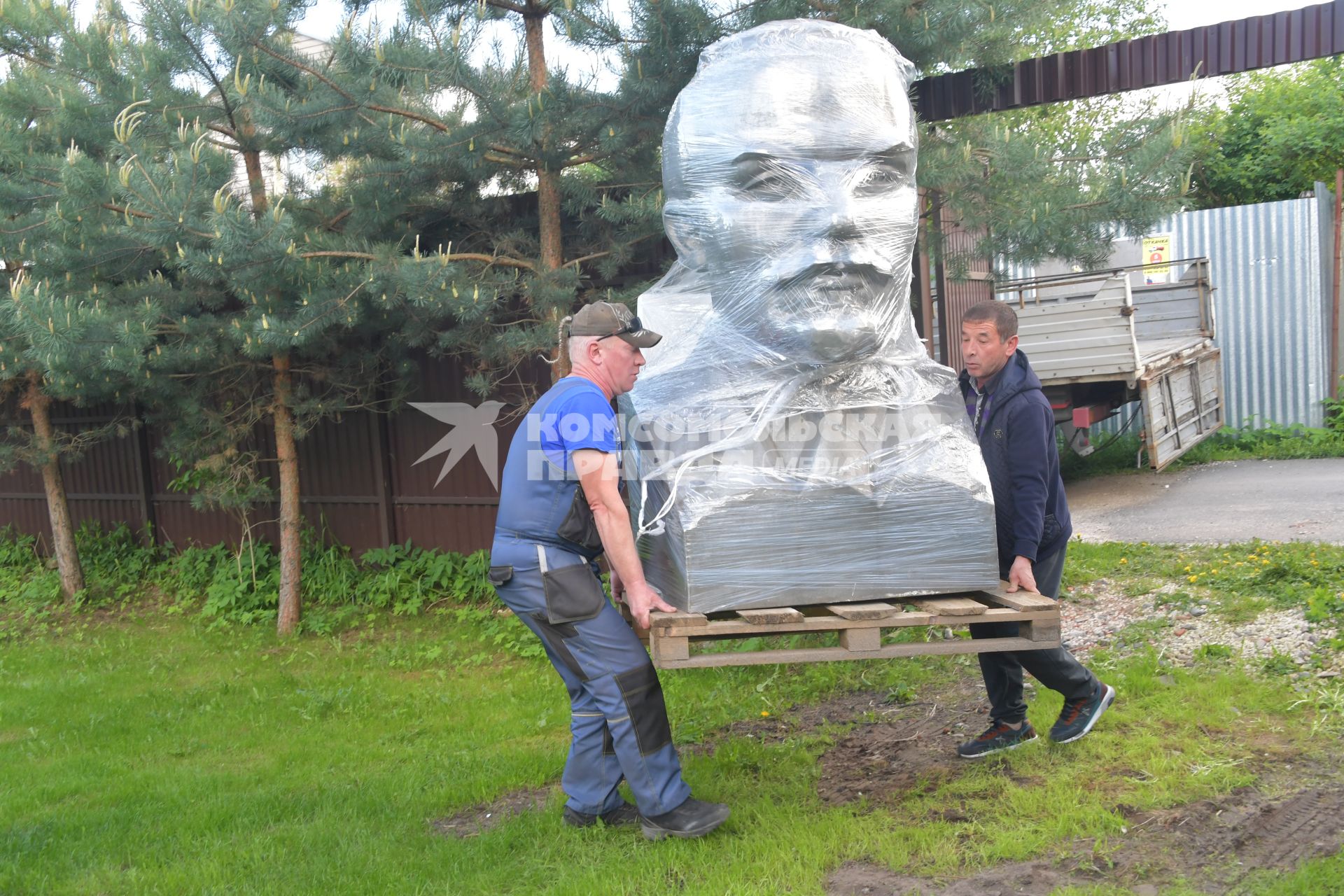 Московская область. Мужчины сгружают бюст Владимира Ленина.