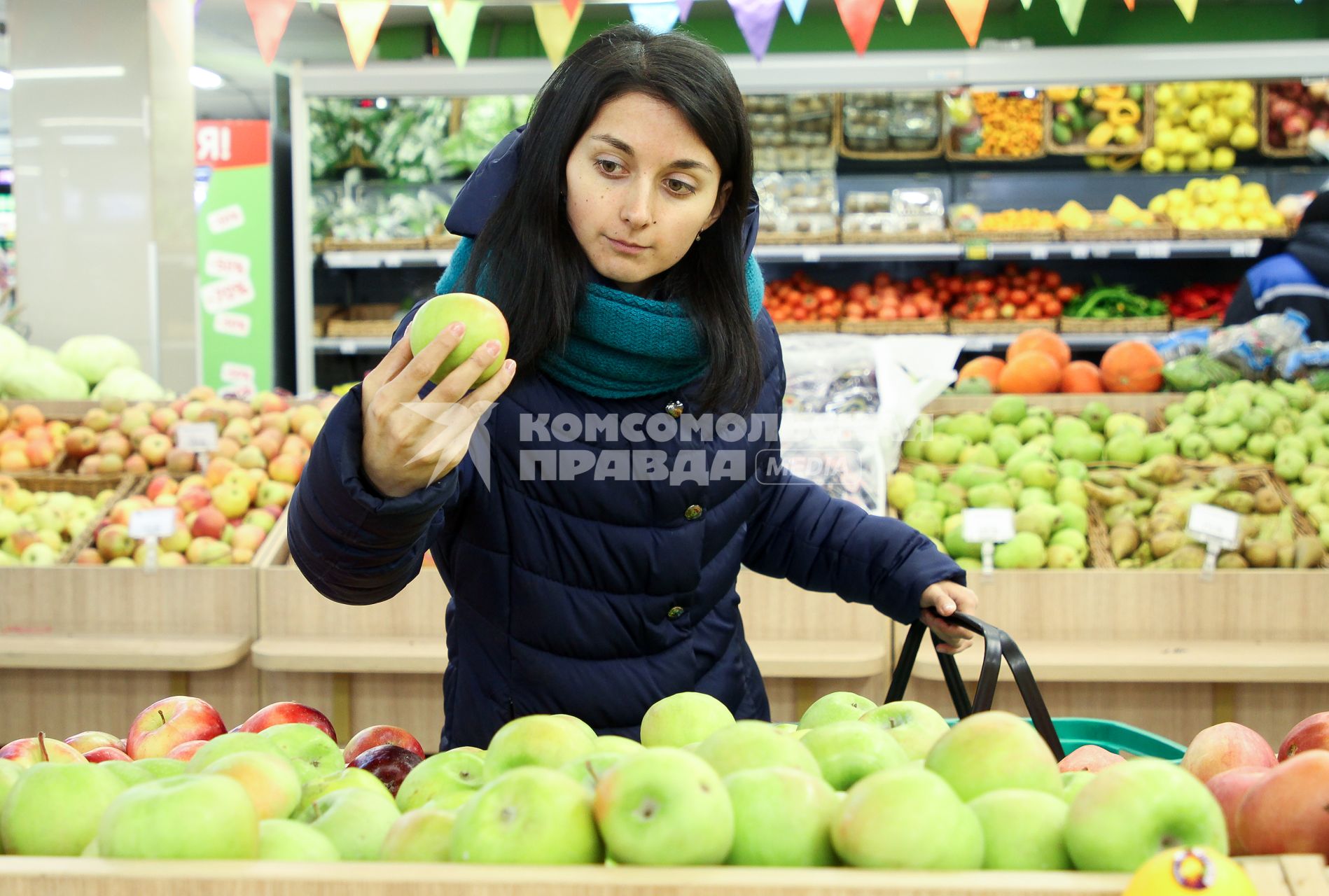 Иркутск. Девушка выбирает фрукты в продуктовом магазине.