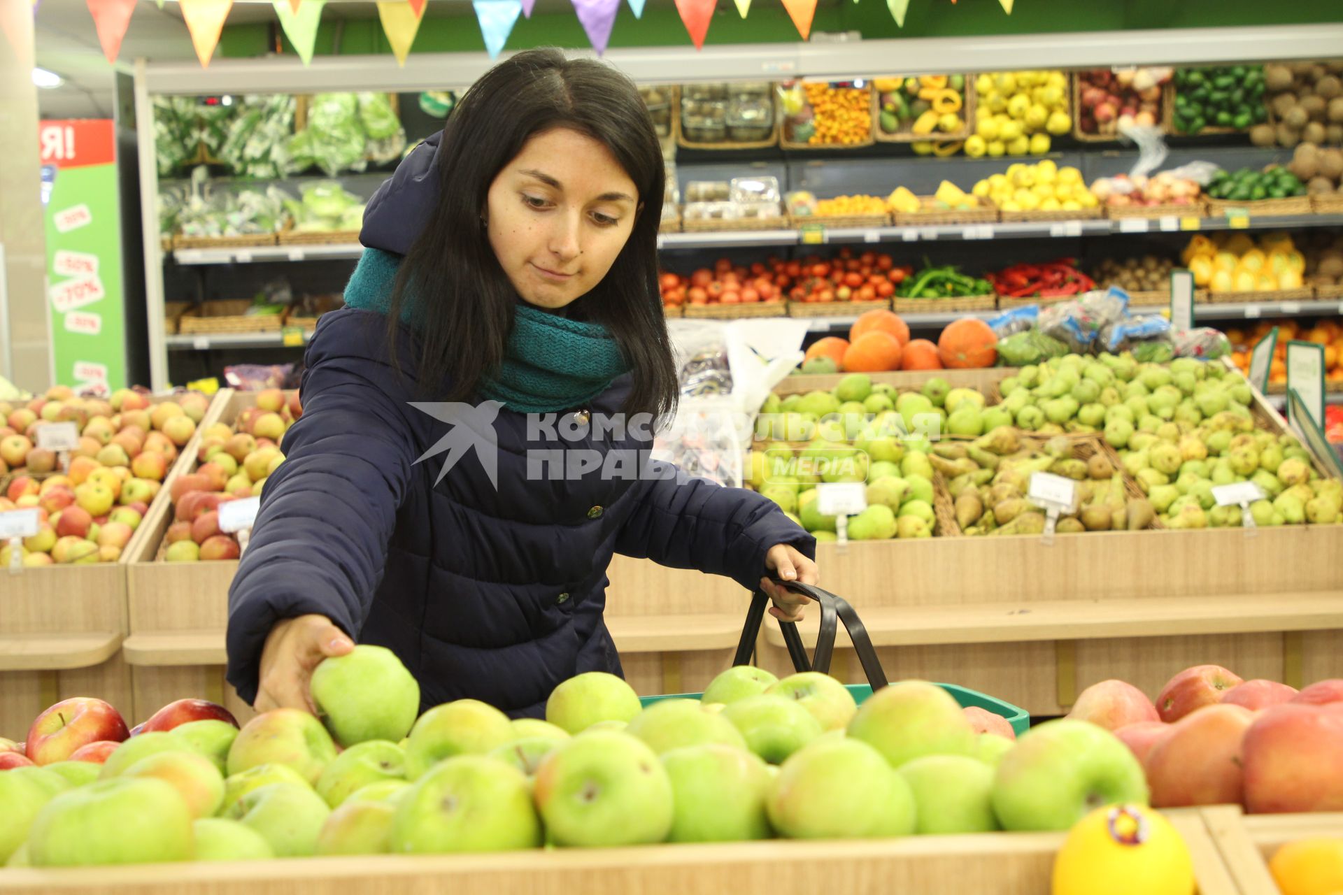 Иркутск. Девушка выбирает фрукты в продуктовом магазине.