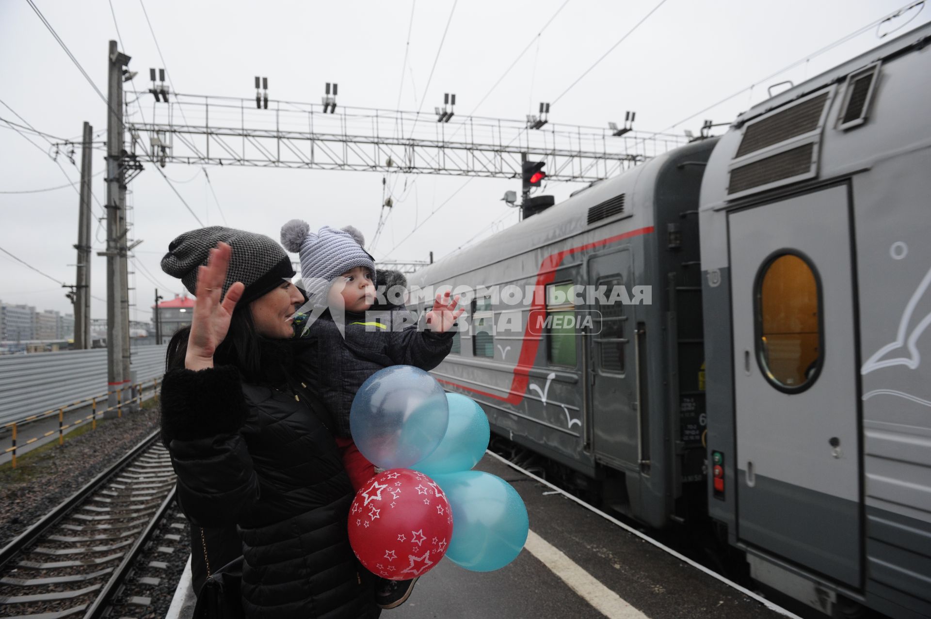 Санкт-Петербург. Женщина с ребенком проважает первый пассажирский  поезд  из Санкт-Петербурга в Севастополь через Крымский мост.