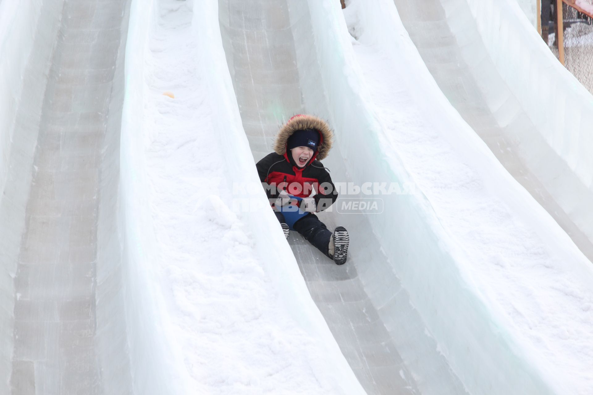 Байкал, Листвянка. Мальчик катается на ледяной горке.