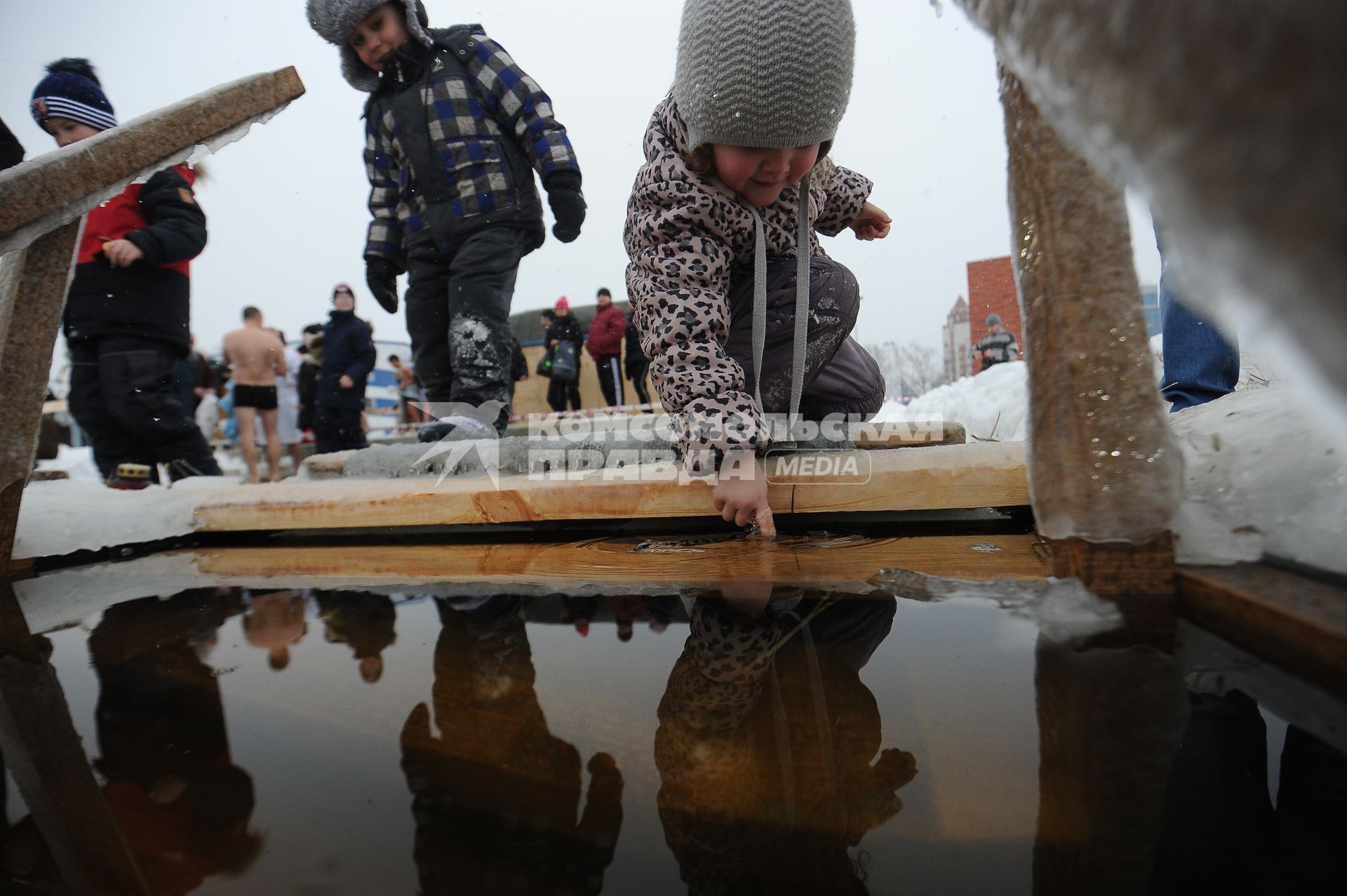 Екатеринбург. Ребенок пробует температуру воды в проруби во время крещенских купаний на Верх-Исетском пруду при температуре -3 градуса