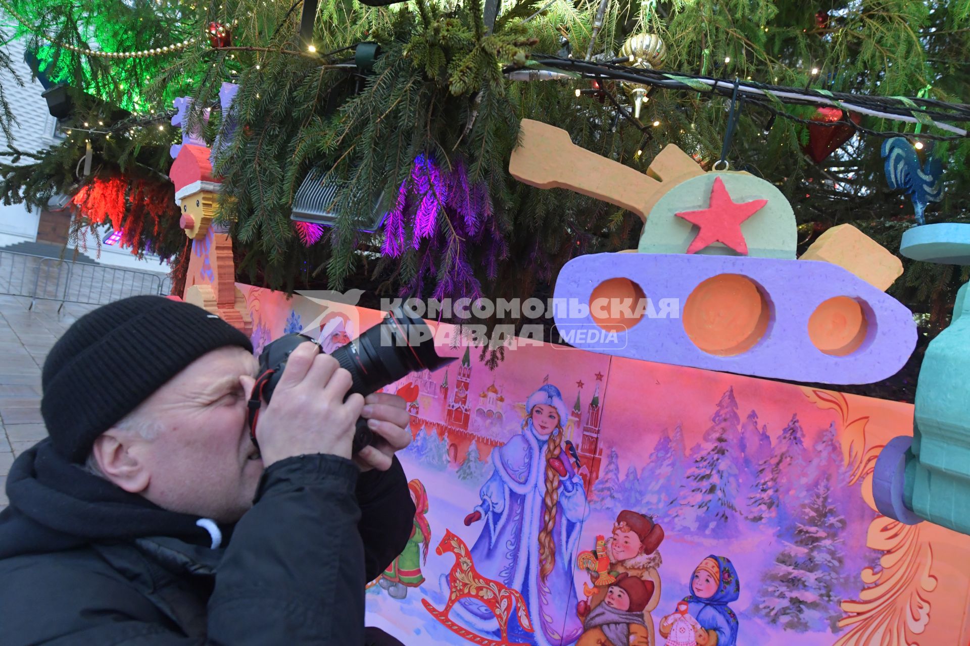 Москва.   Мужчина фотографирует  игрушки на новогодней елке Московского Кремля.