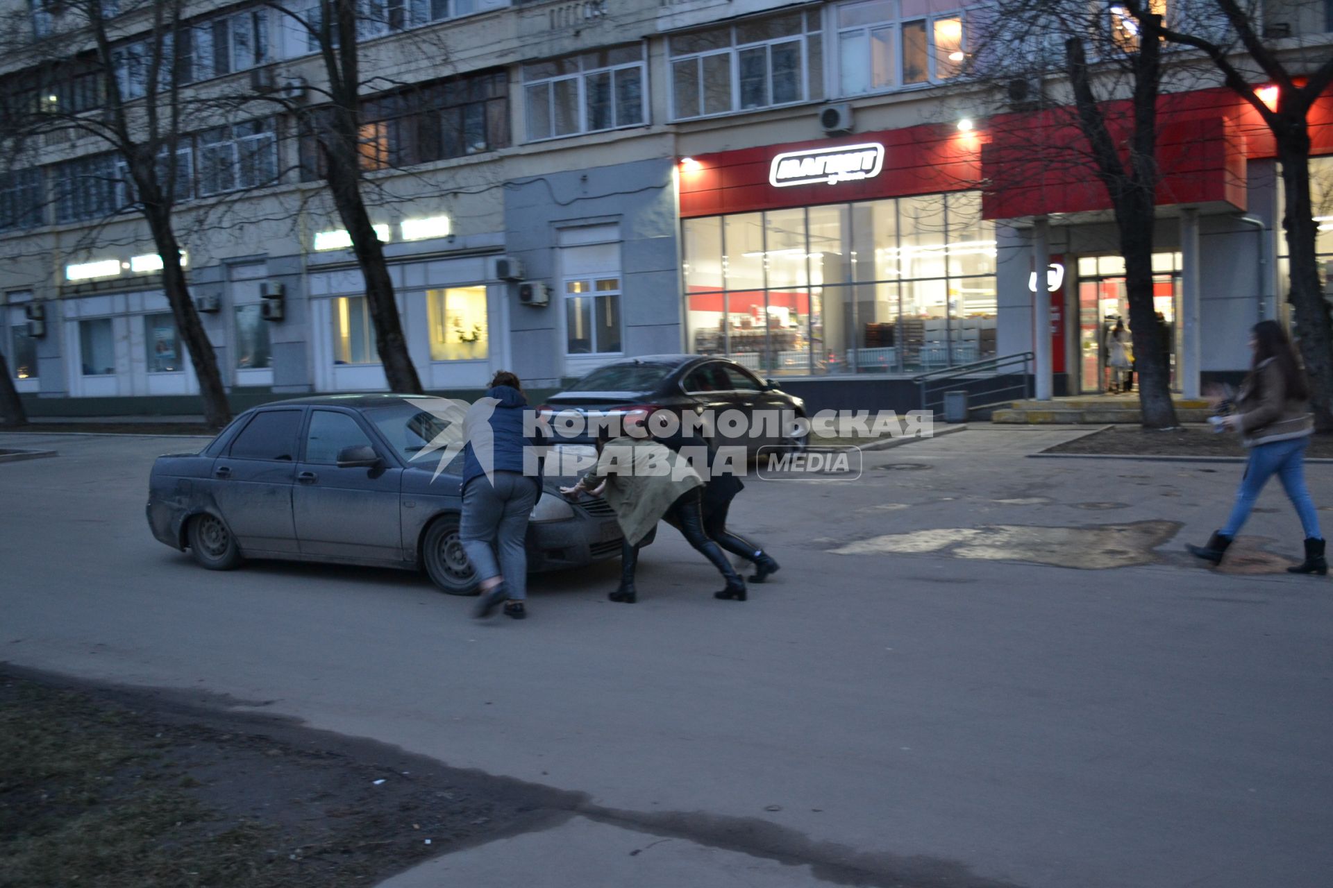 Москва. Девушки толкают автомобиль.