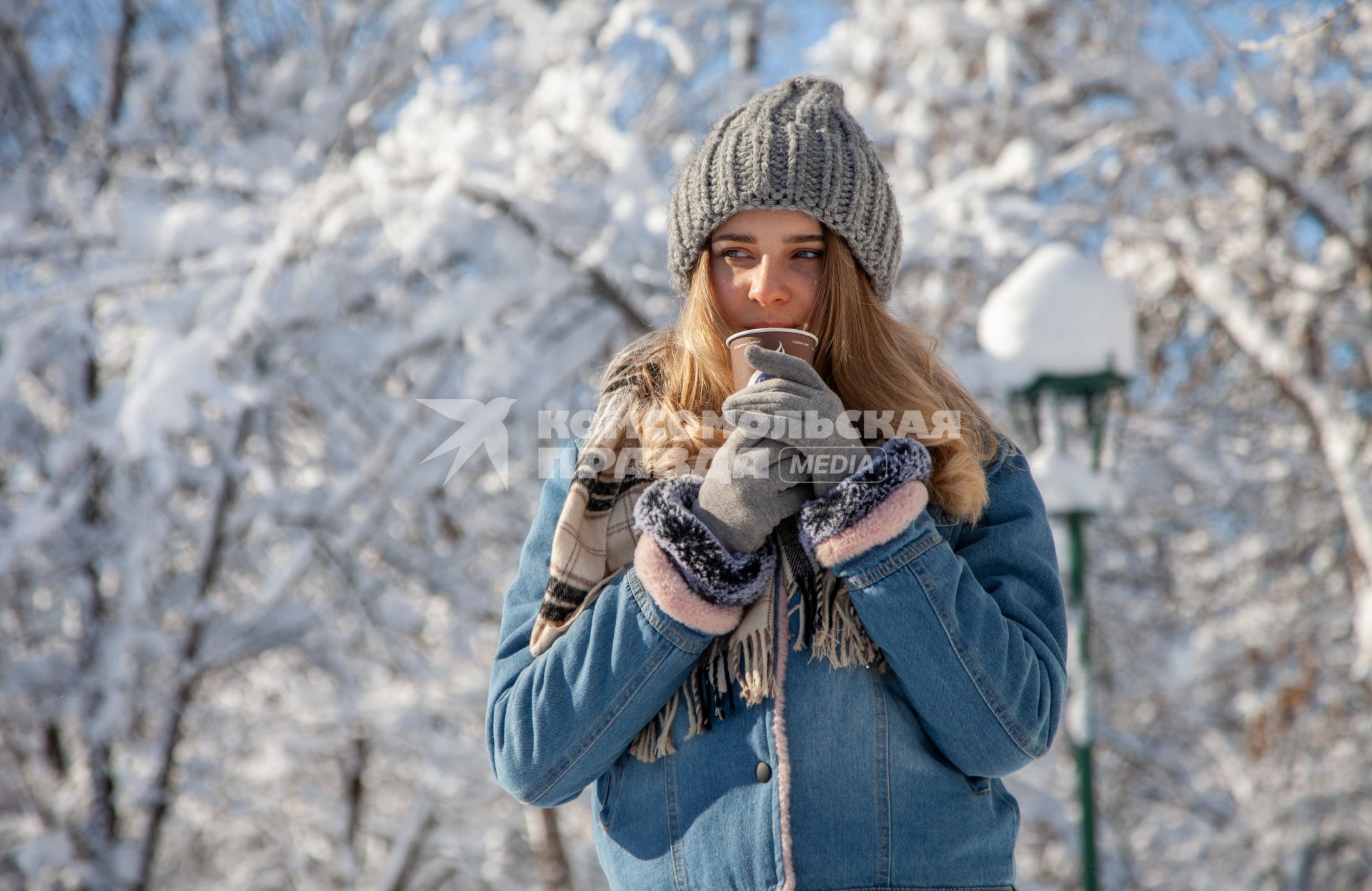 Пермь.  Девушка пьет кофе на улице зимой.