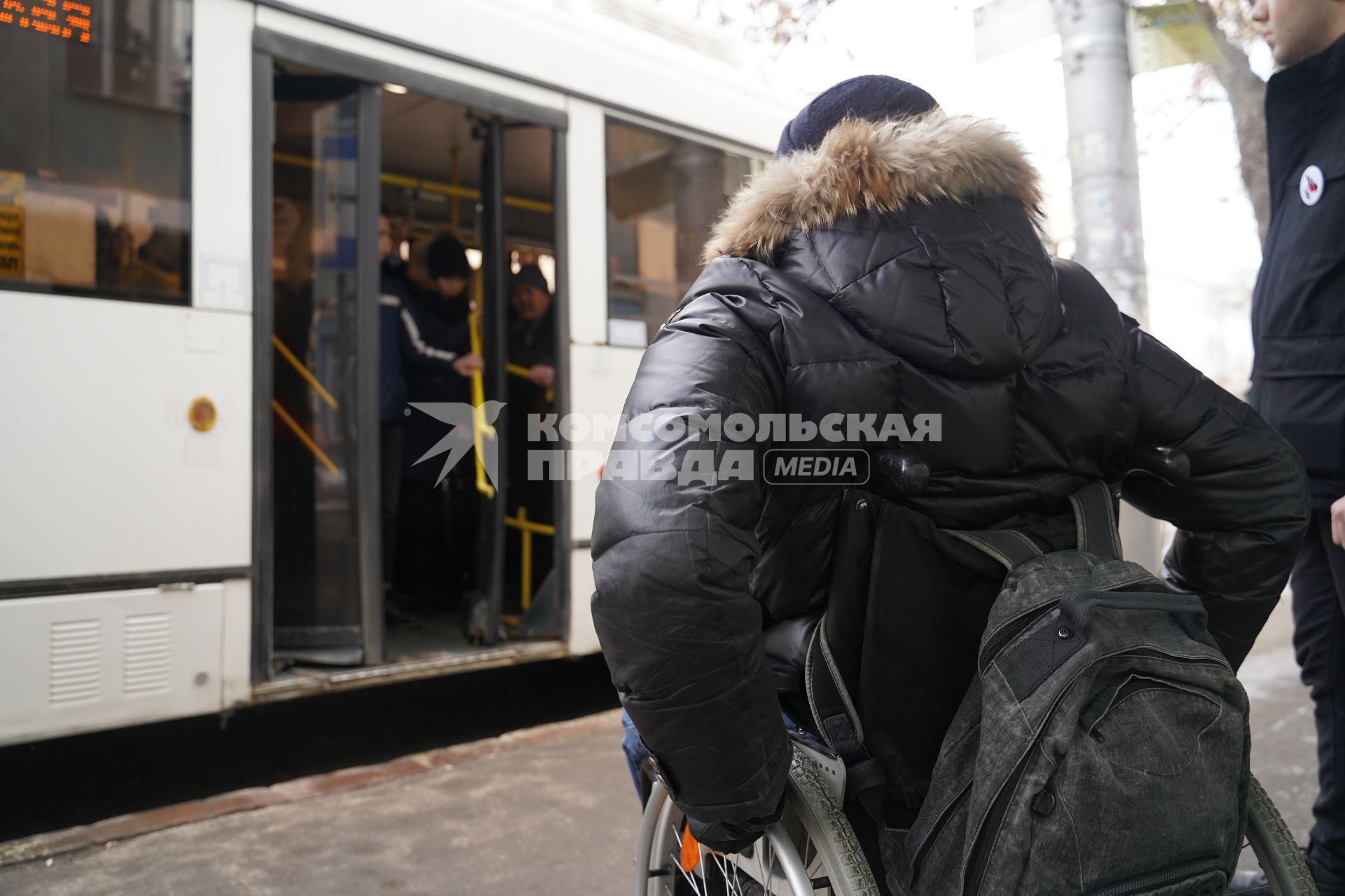 Самара. Человек в инвалидном кресле на остановке общественного транспорта.