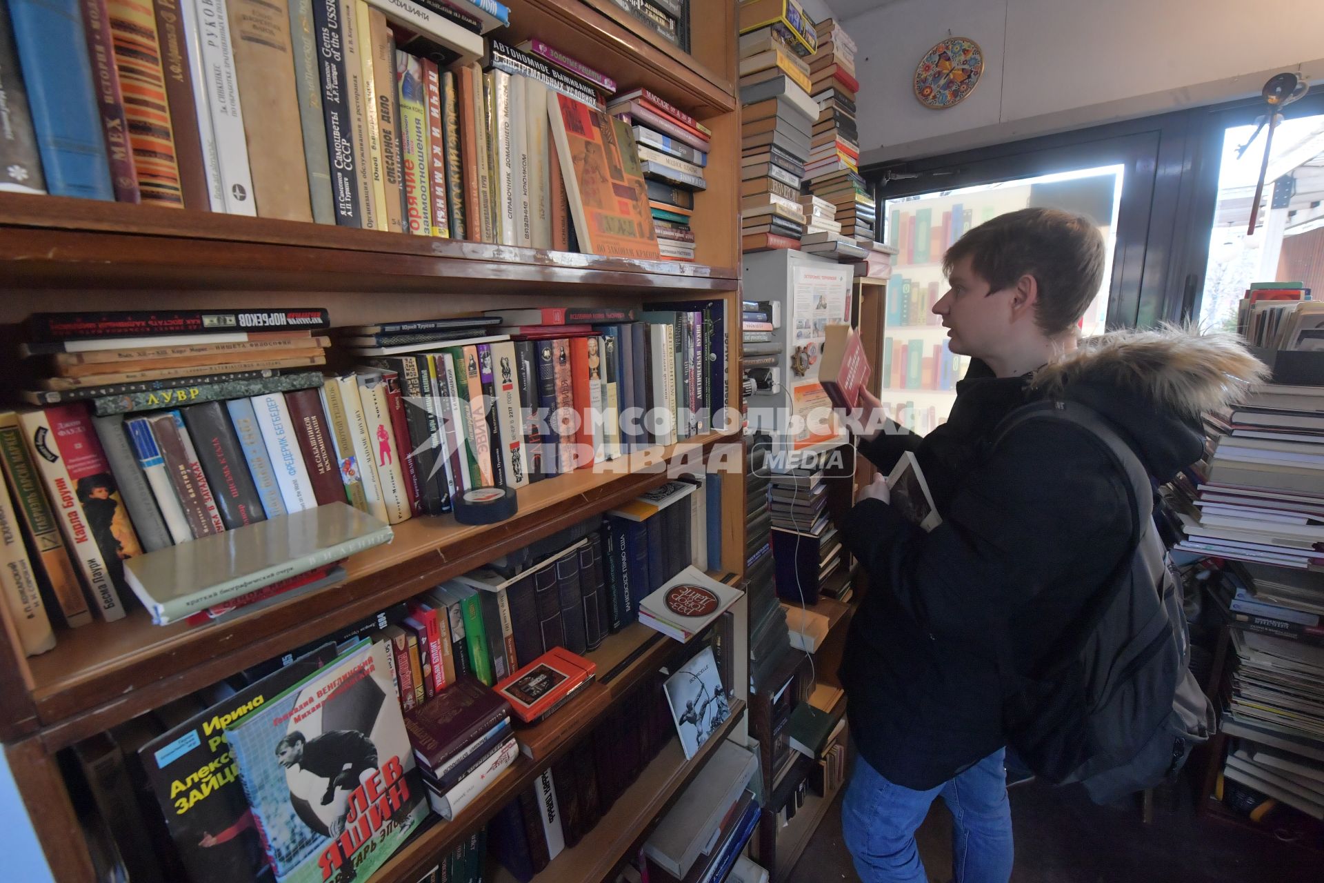 Москва. Покупатель  в книжном павильоне  на фестивале `Букинист` на Новом Арбате.