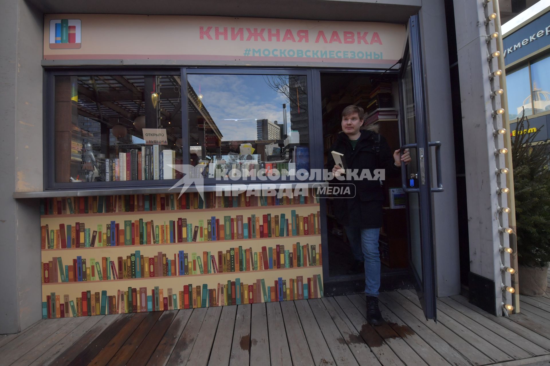 Москва. Покупательв книжном павильоне  на фестивале `Букинист` на Новом Арбате.