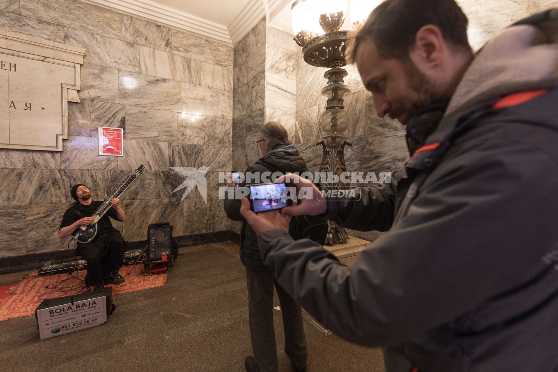 Москва.  Мужчина  играет на ситаре на станции метро `Арбатская`.