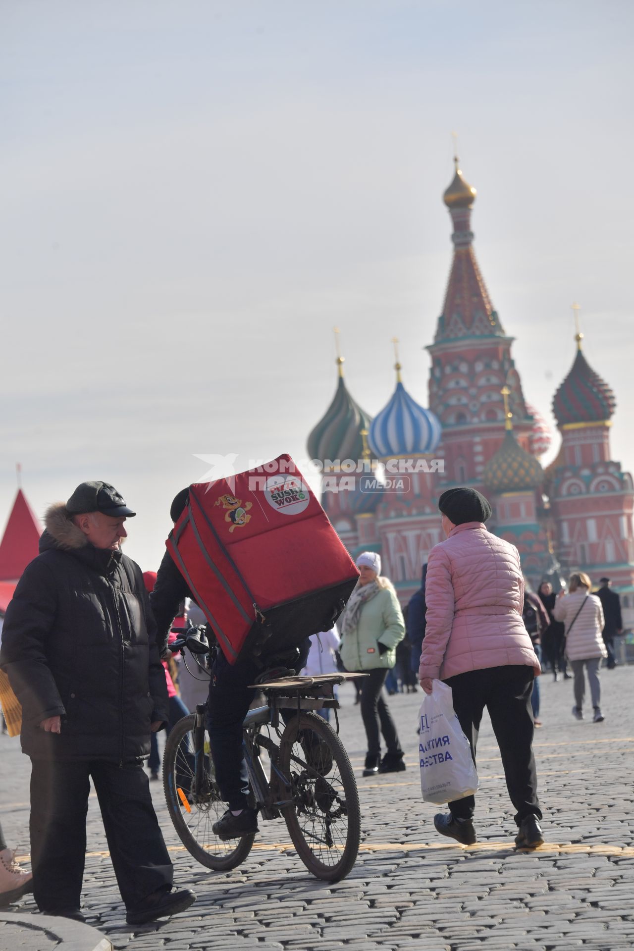 Москва.  Сотрудник сервиса доставки еды на Красной площади.