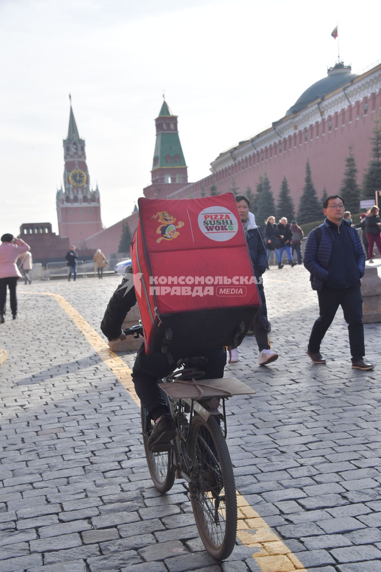 Москва.  Сотрудник сервиса доставки еды на Красной площади.