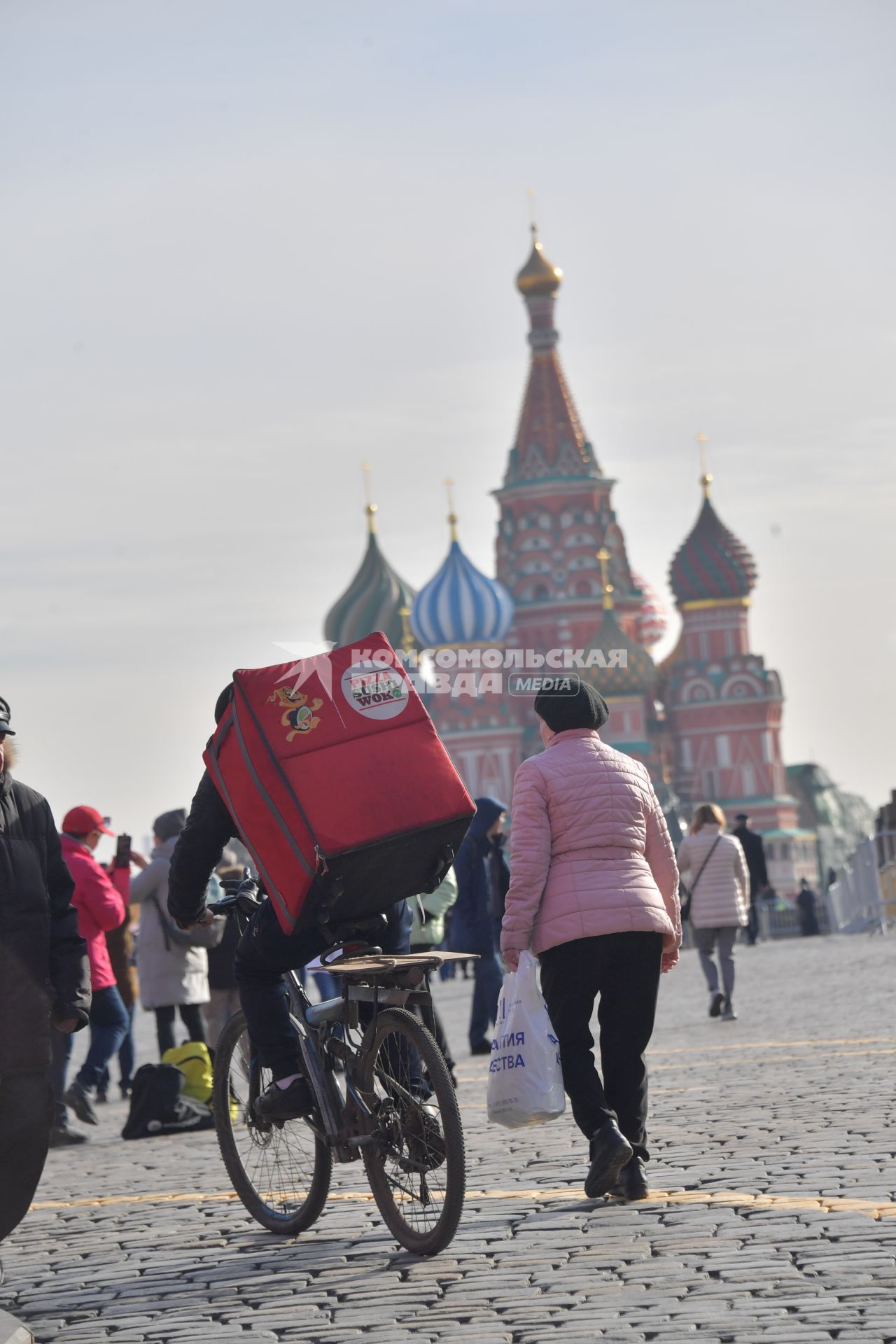 Москва.  Сотрудник сервиса доставки еды на Красной площади.