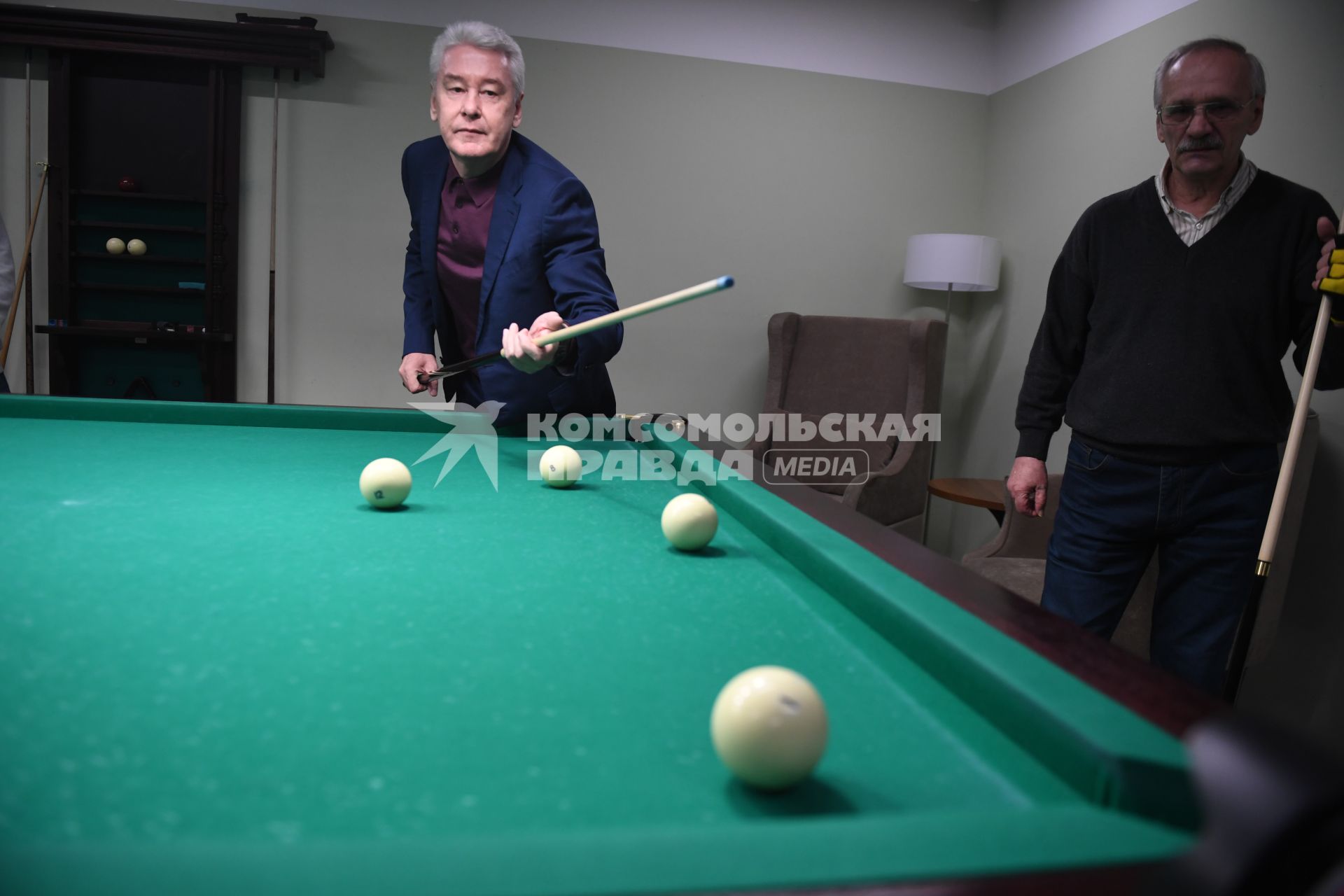 Москва.  Мэр Москвы Сергей Собянин (слева)  во время  игры в бильярд с посетителями  нового социального  центра `Мой социальный центр` для пенсионеров  на улице Сергия Радонежского.