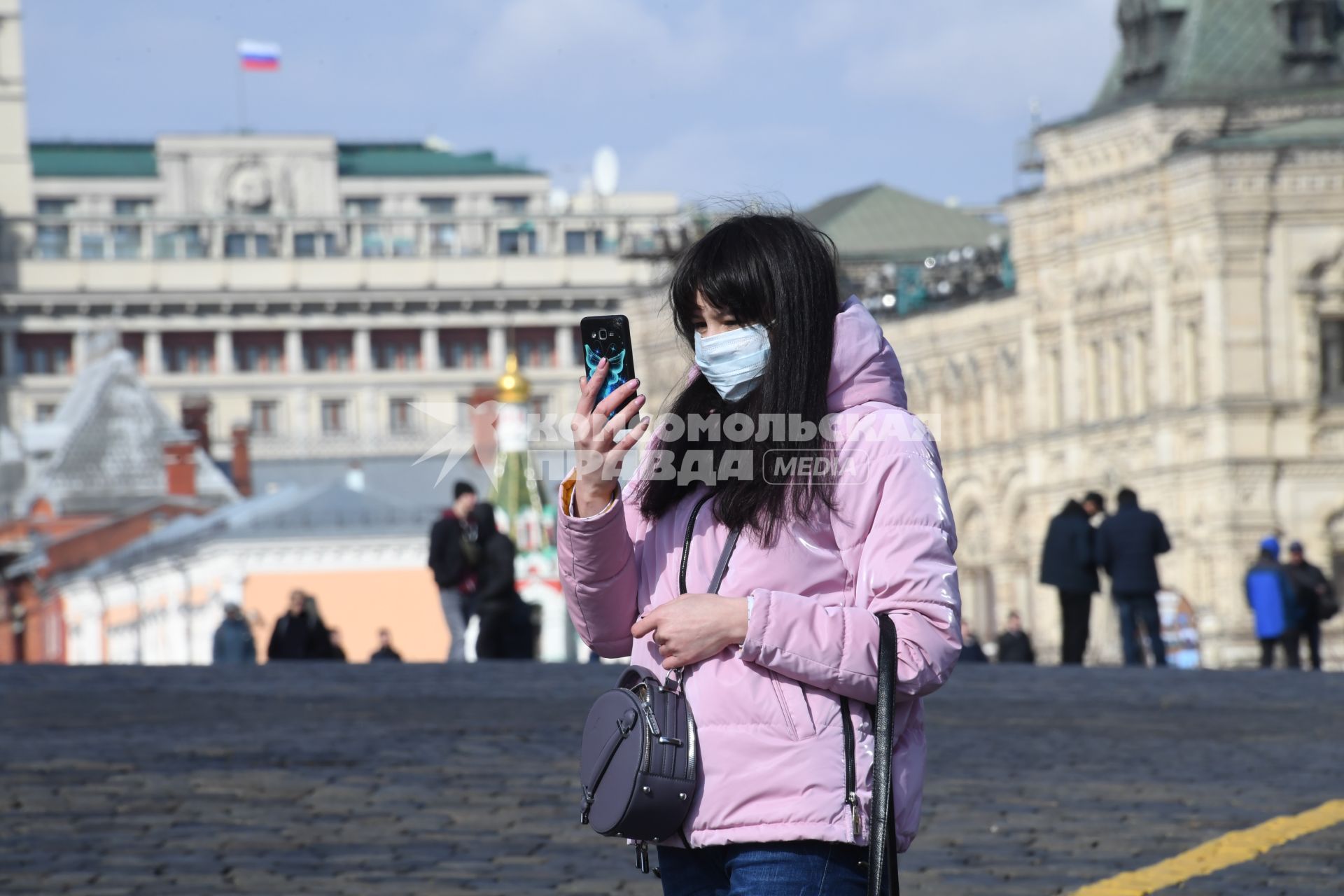 Москва.  Женщина в медицинской маске на улице города.