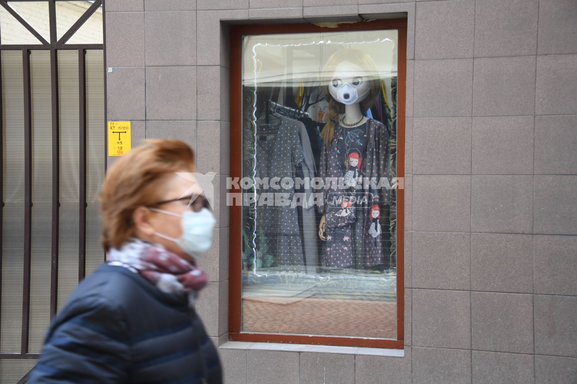 Москва.  Женщина в медицинской маске на улице города.
